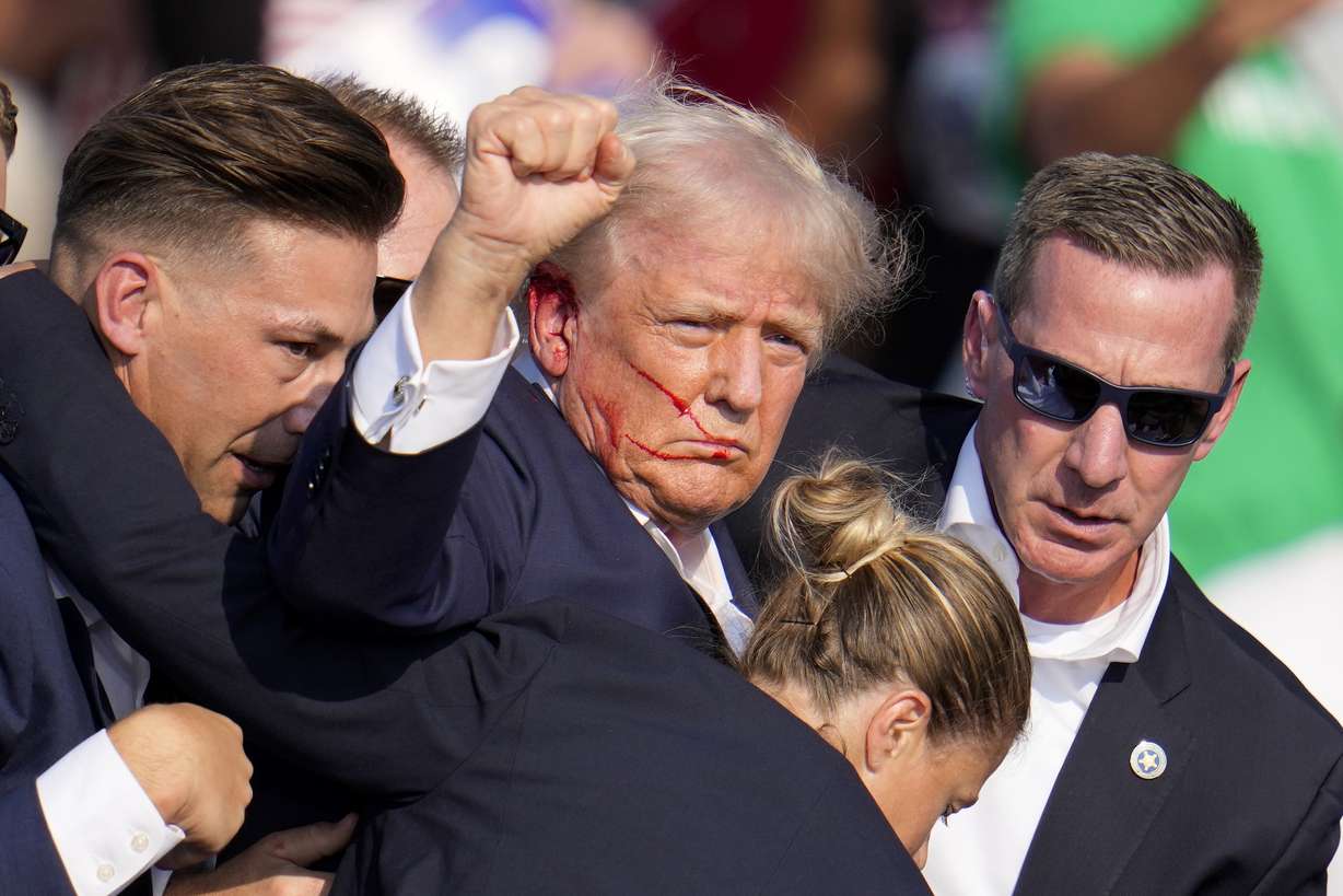 Republican presidential candidate former President Donald Trump is helped off the stage by U.S. Secret Service agents at a campaign event in Butler, Pa., on Saturday.