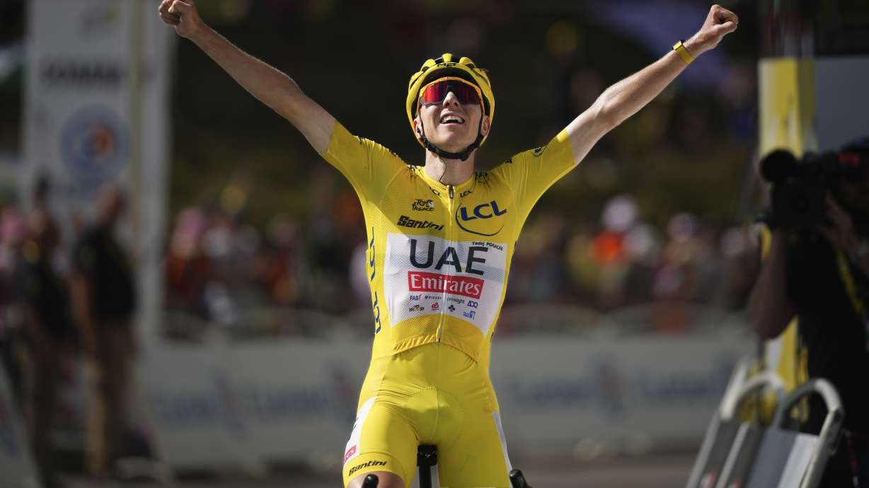 Stage winner Slovenia's Tadej Pogacar, wearing the overall leader's yellow jersey, celebrates as he crosses the finish line of the fifteenth stage of the Tour de France cycling race over 198 kilometers (123 miles) with start in Loudenvielle and finish on Plateau de Beille, France, Sunday, July 14, 2024.