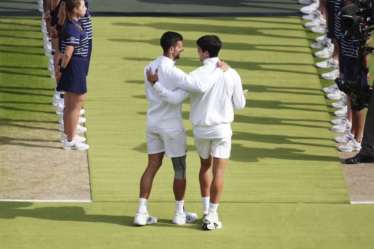 Carlos Alcaraz speaks with Novak Djokovic after the men's singles final at the Wimbledon tennis championships in, Sunday, July 14, 2024.