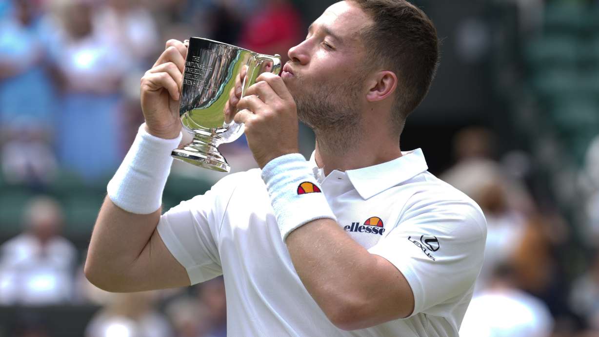 Alfie Hewett of Britain kisses his trophy after defeating Martin De La Puente of Spain in the men's wheelchair singles final at the Wimbledon tennis championships in London, Sunday, July 14, 2024.