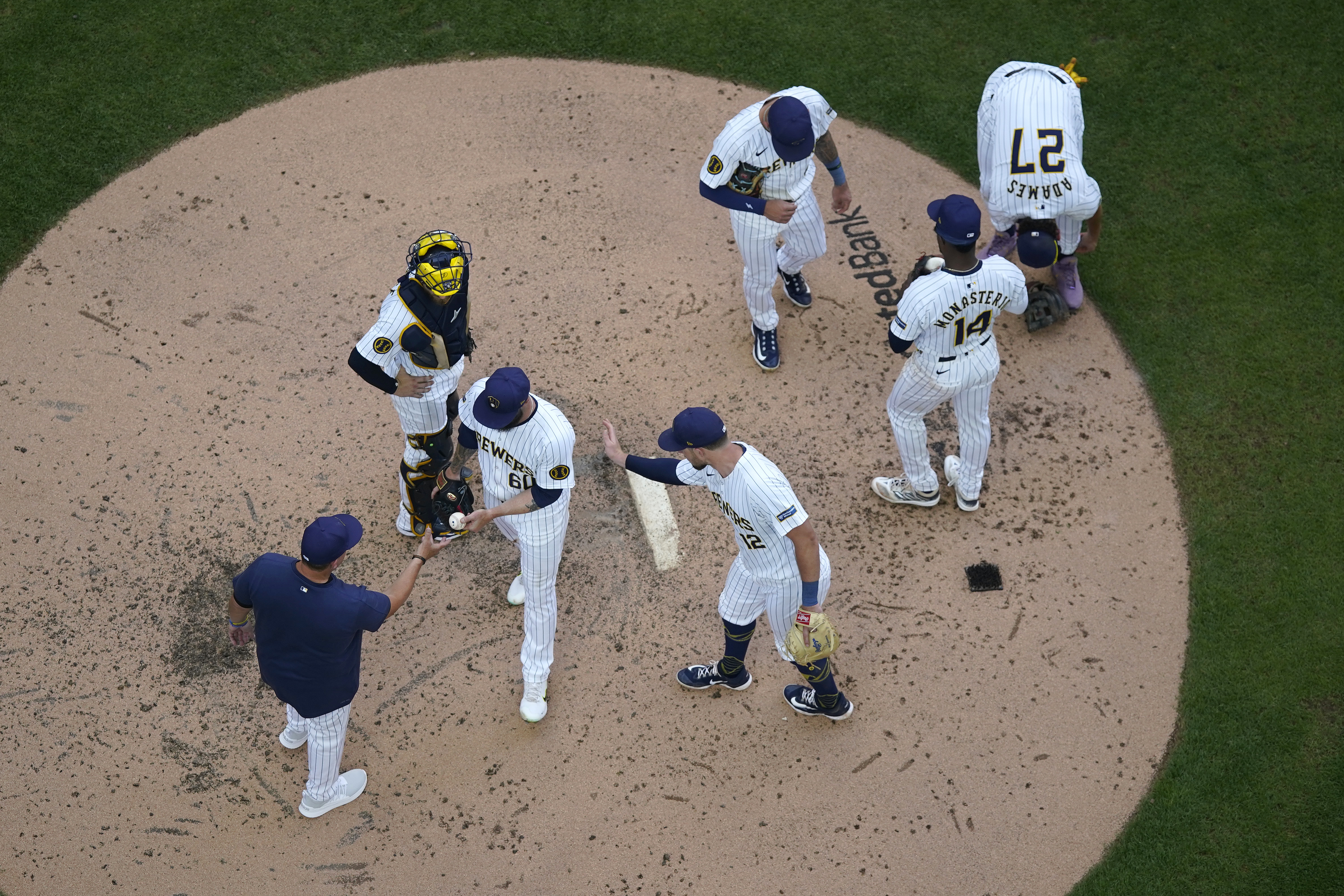 Milwaukee Brewers' Dallas Keuchel (60) hands the ball to manager Pat Murphy, left, as he is taken out during the fourth inning of a baseball game against the Washington Nationals, Saturday, July 13, 2024, in Milwaukee. 