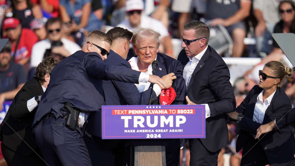 Republican presidential candidate former President Donald Trump is helped off the stage at a campaign event in Butler, Pa., on Saturday. The FBI is investigating the attack as a potential act of domestic terrorism.