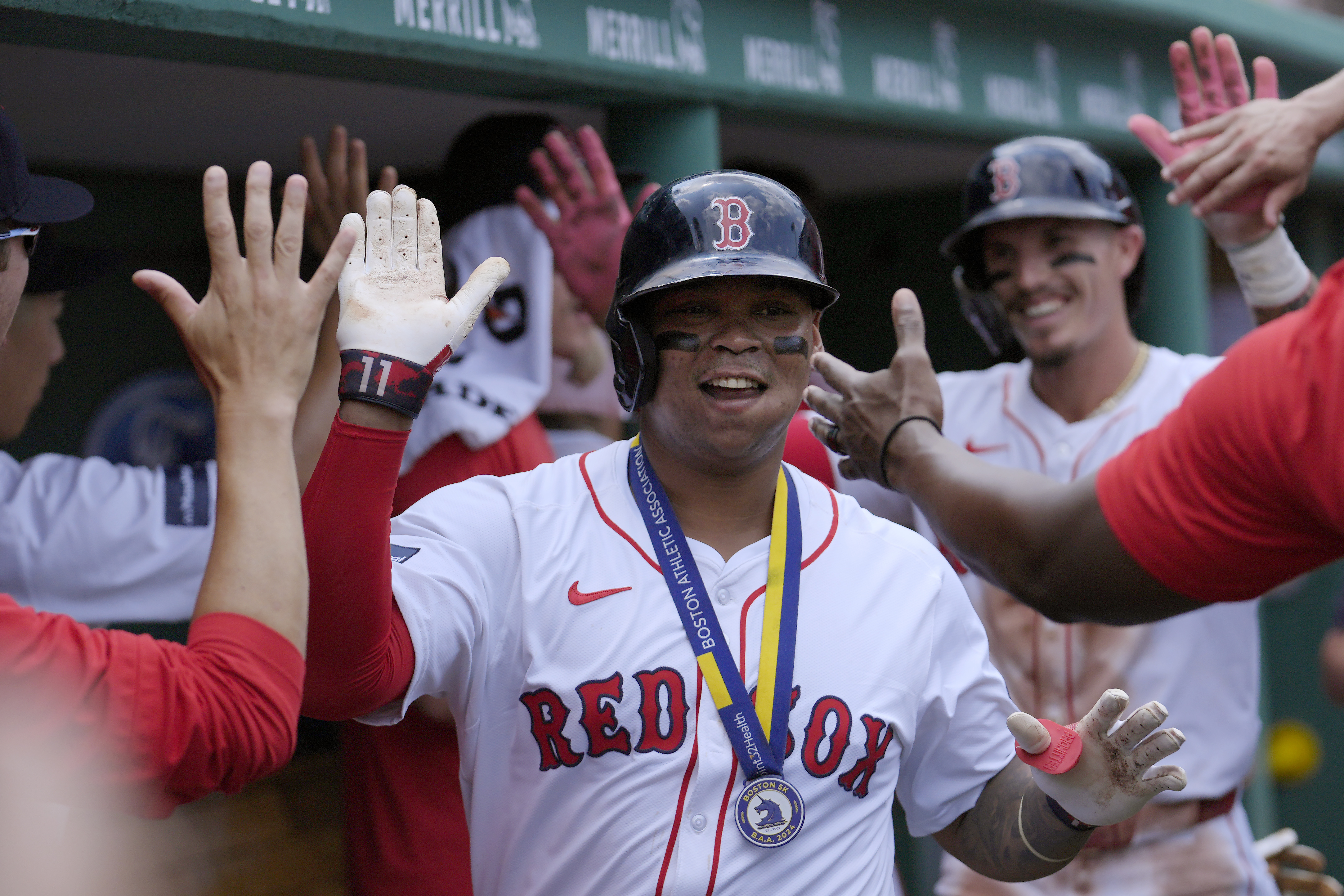 Boston Red Sox's Rafael Devers celebrates in the dugout with teammates after scoring on his two-run home in the first inning of a baseball game against the Kansas City Royals, Sunday, July 14, 2024, in Boston. 