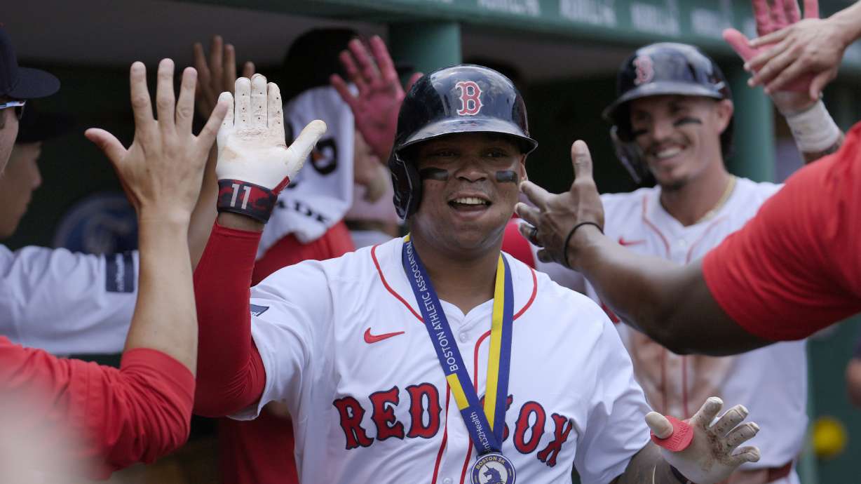 Boston Red Sox's Rafael Devers celebrates in the dugout with teammates after scoring on his two-run home in the first inning of a baseball game against the Kansas City Royals, Sunday, July 14, 2024, in Boston.