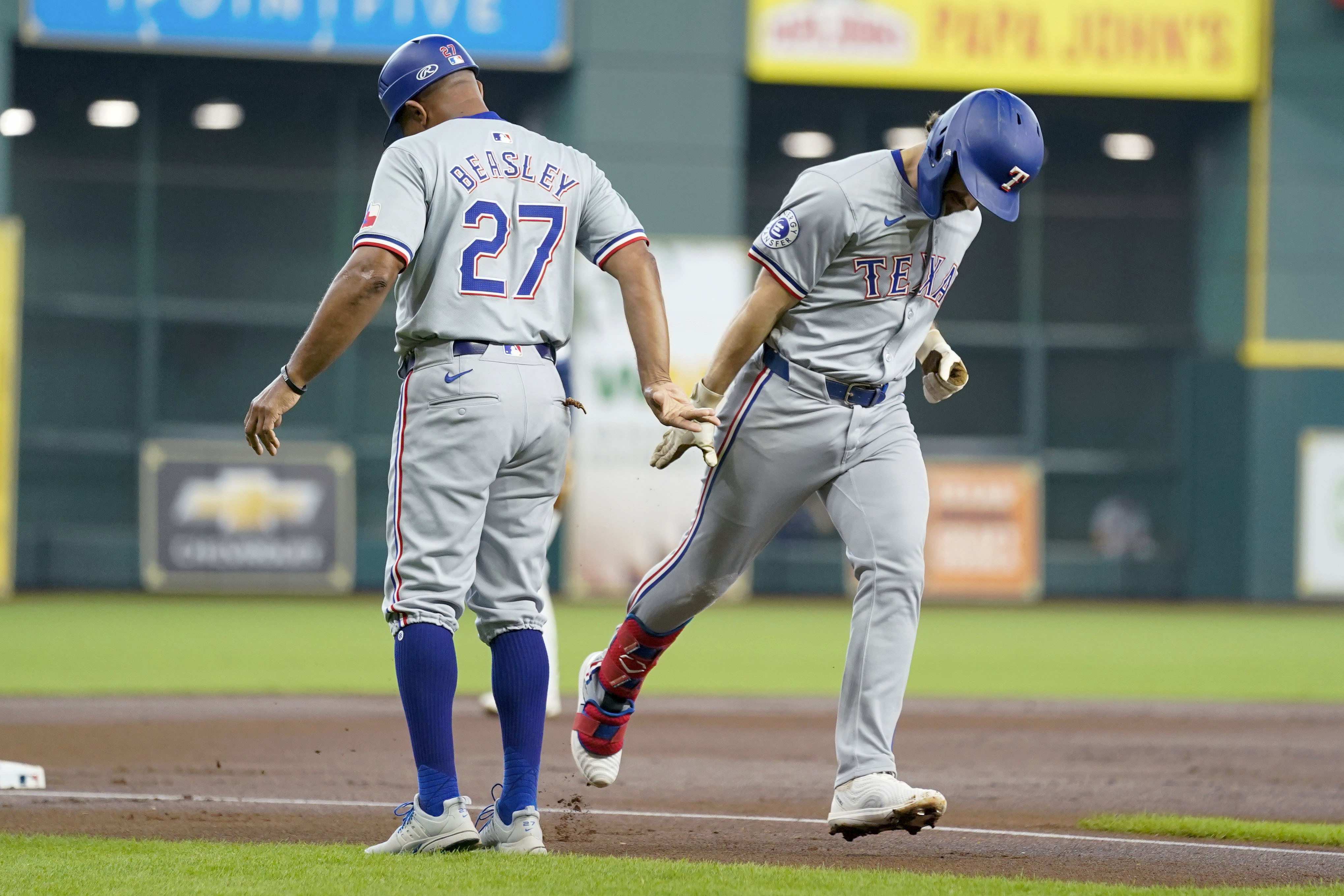 Texas Rangers' Josh Smith, right, celebrates his two-run home run against the Houston Astros with third base coach Tony Beasley during the first inning of a baseball game, Sunday, July 14, 2024, in Houston. 