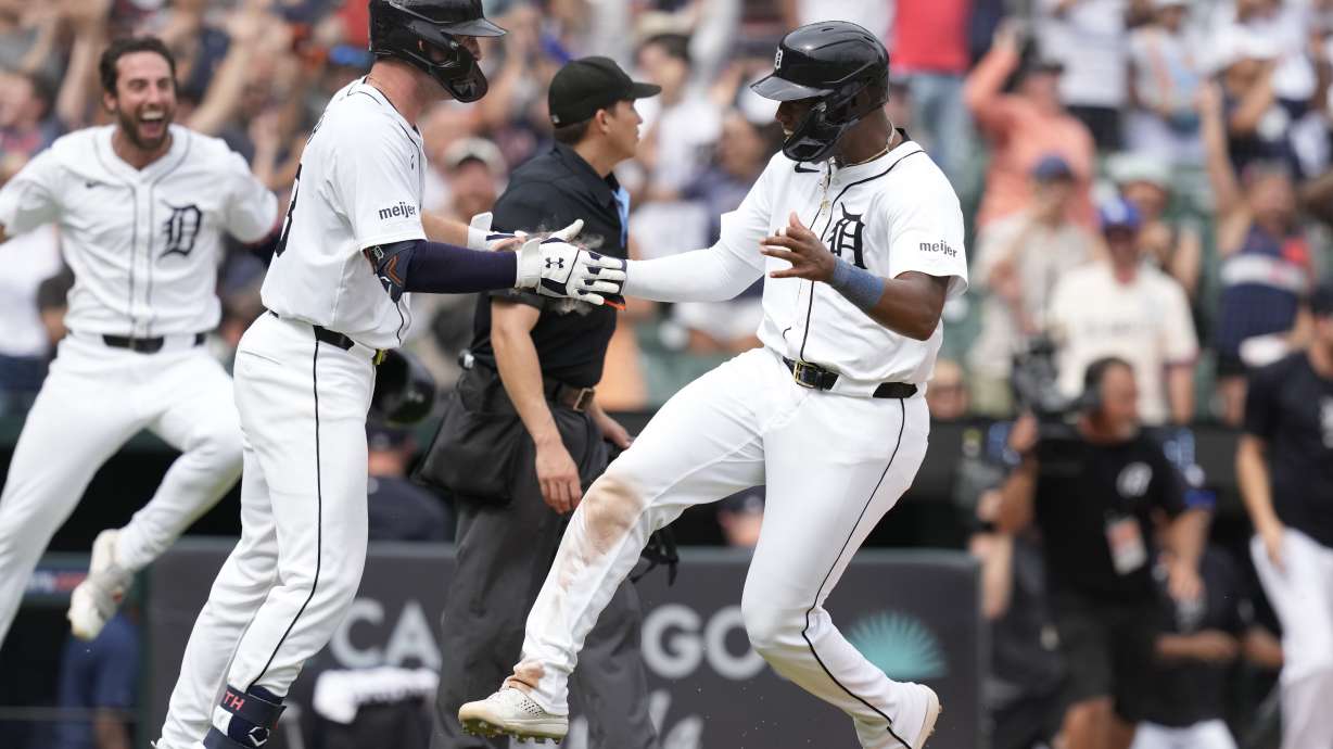 Detroit Tigers' Justyn-Henry Malloy is greeted at home after scoring to defeat the Los Angeles Dodgers in the 10th inning of a baseball game, Sunday, July 14, 2024, in Detroit.
