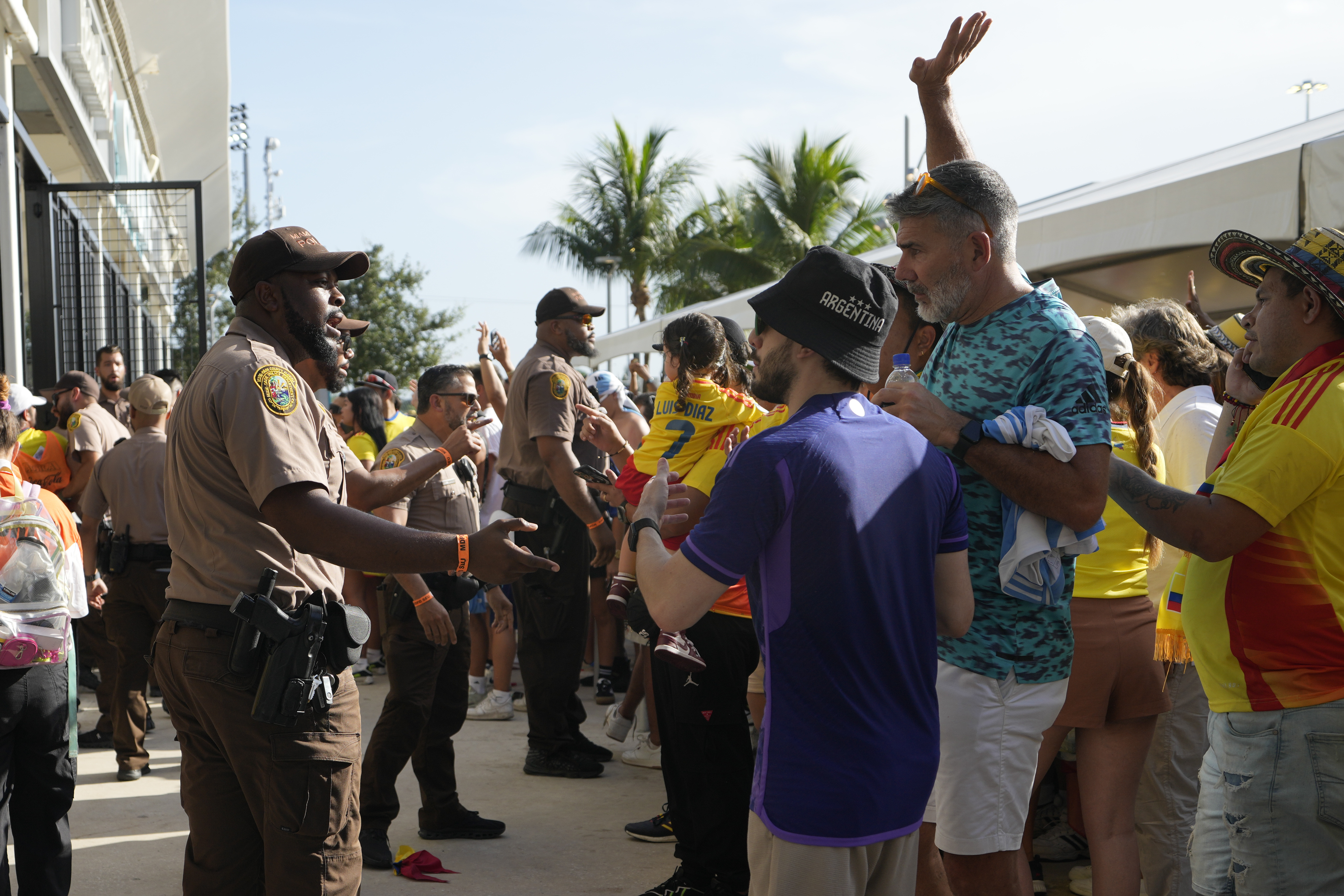 Policemen talk with fans outside the stadium prior to the Copa America final soccer match between Argentina and Colombia in Miami Gardens, Fla., Sunday, July 14, 2024. 