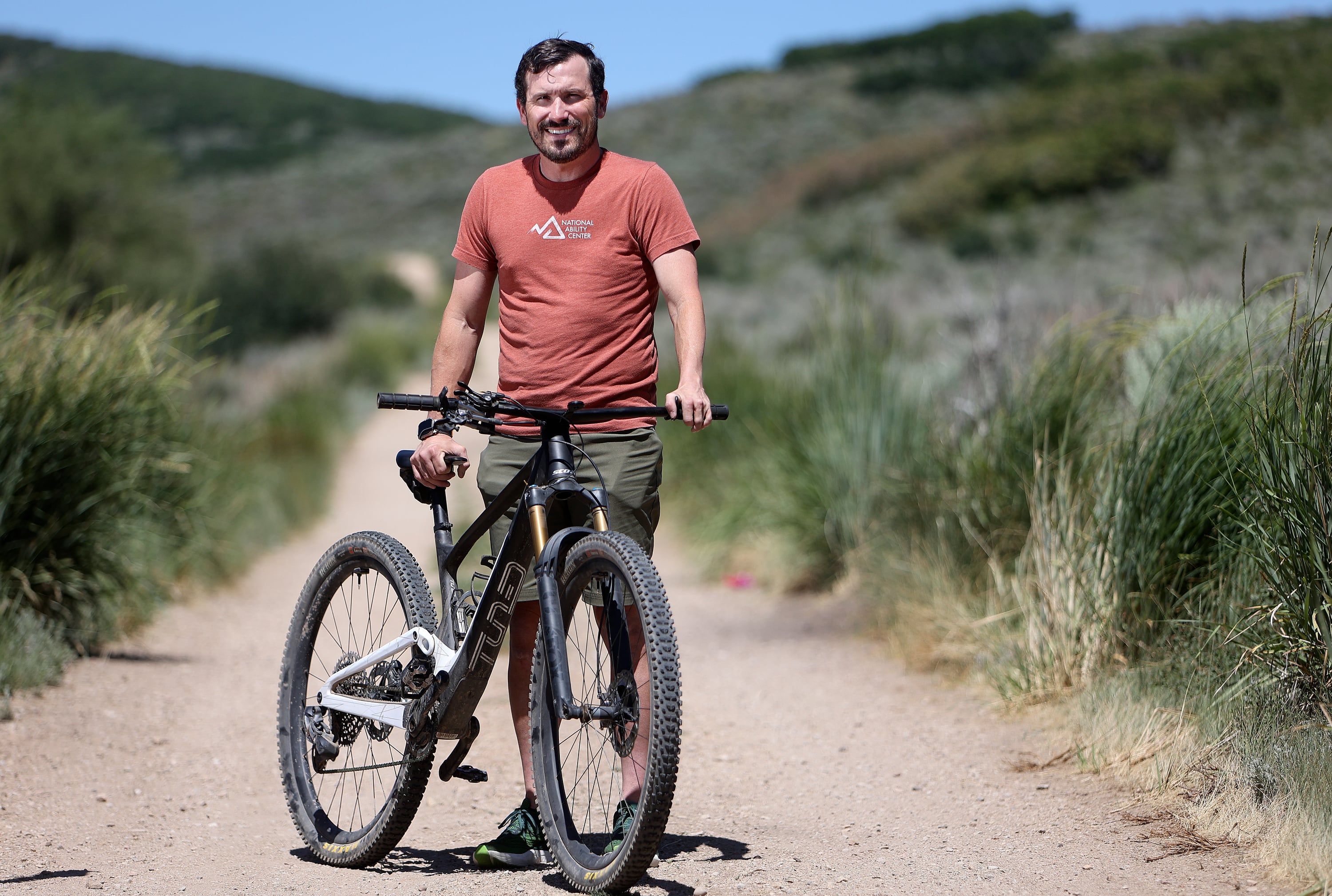 Paracyclist Steven Wilke poses for a portrait with his mountain bike, which has been modified to have all gear shifters and brakes on one side of the handlebars, near the National Ability Center in Park City on July 3.