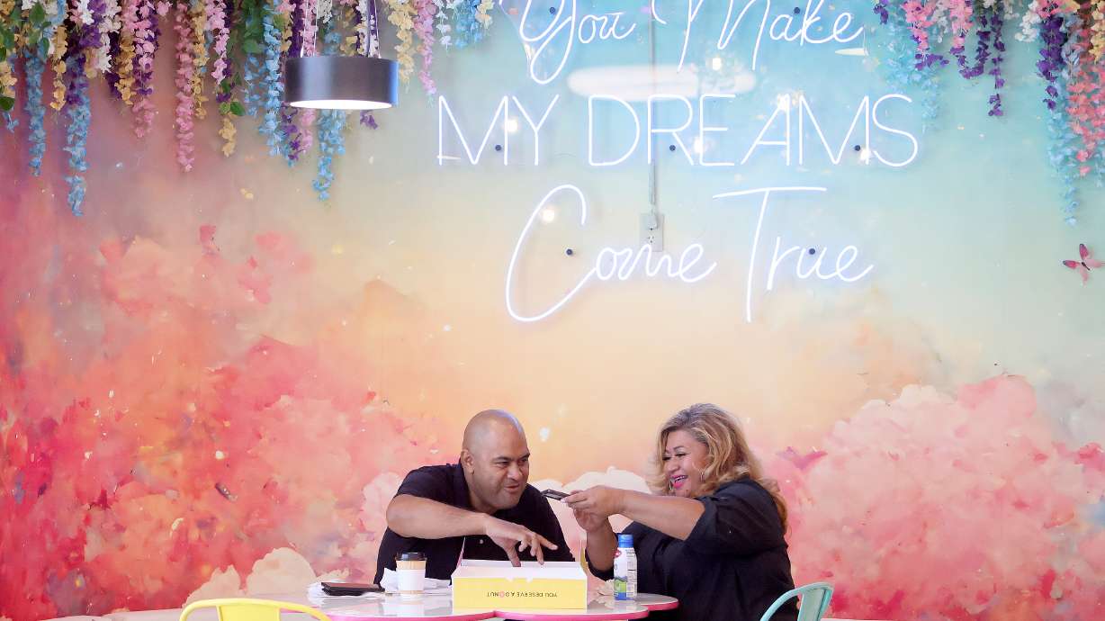 Kirk and Ling Ava photograph their doughnuts before eating them at the Other Side Donuts in Salt Lake City on Thursday.