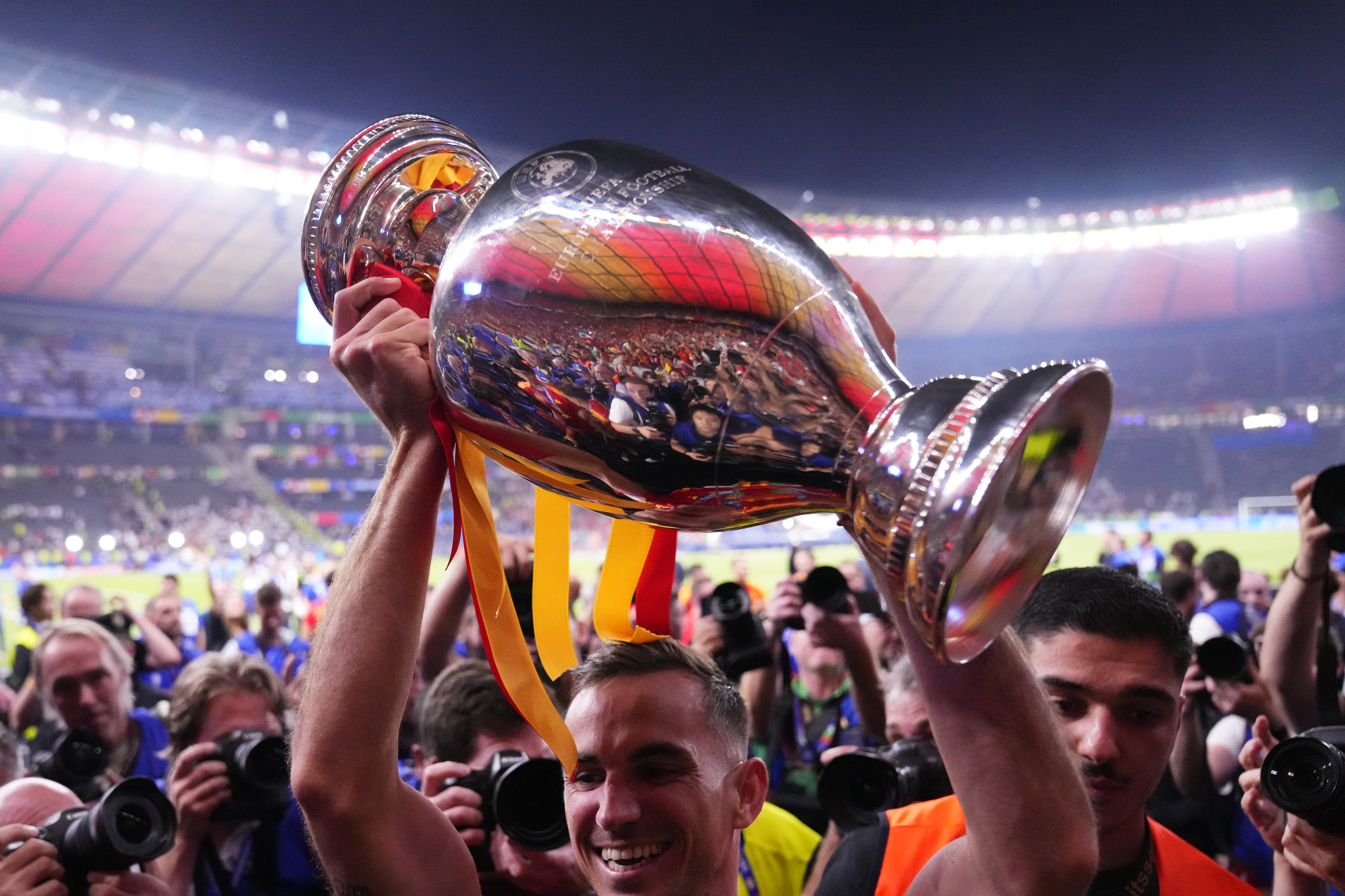 Spain's Dani Olmo holds up the trophy to the fans after winning the final match between Spain and England at the Euro 2024 soccer tournament in Berlin, Germany, Sunday, July 14, 2024. Spain won 2-1. 