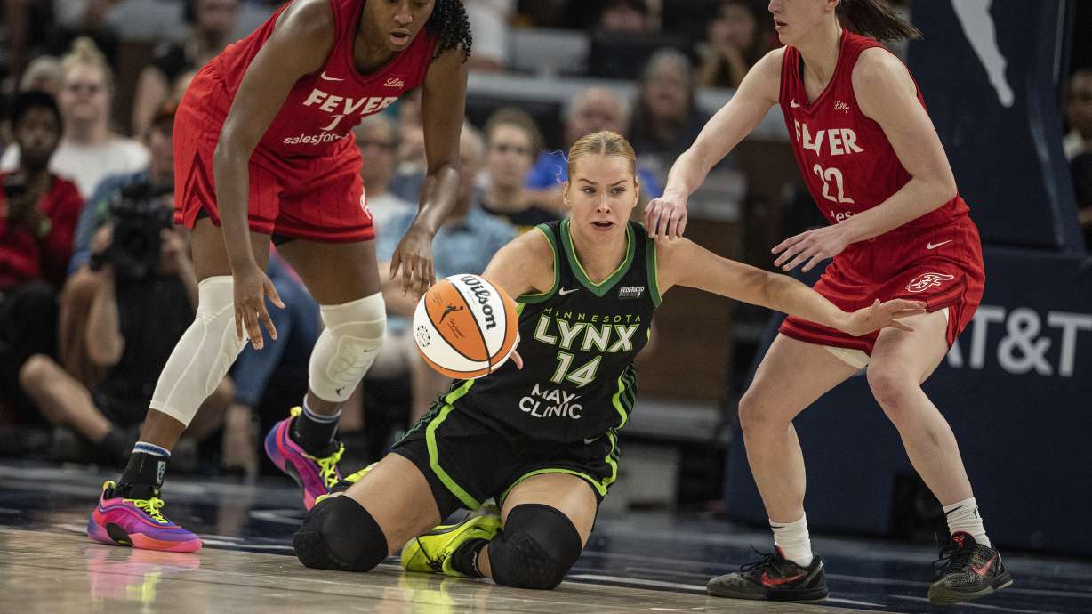Minnesota Lynx forward Dorka Juhasz (14) is pressured by Indiana Fever forward Aliyah Boston (7), left, and Fever guard Caitlin Clark (22) during the fourth quarter of a WNBA basketball game, Sunday, July 14, 2024, in Minneapolis.