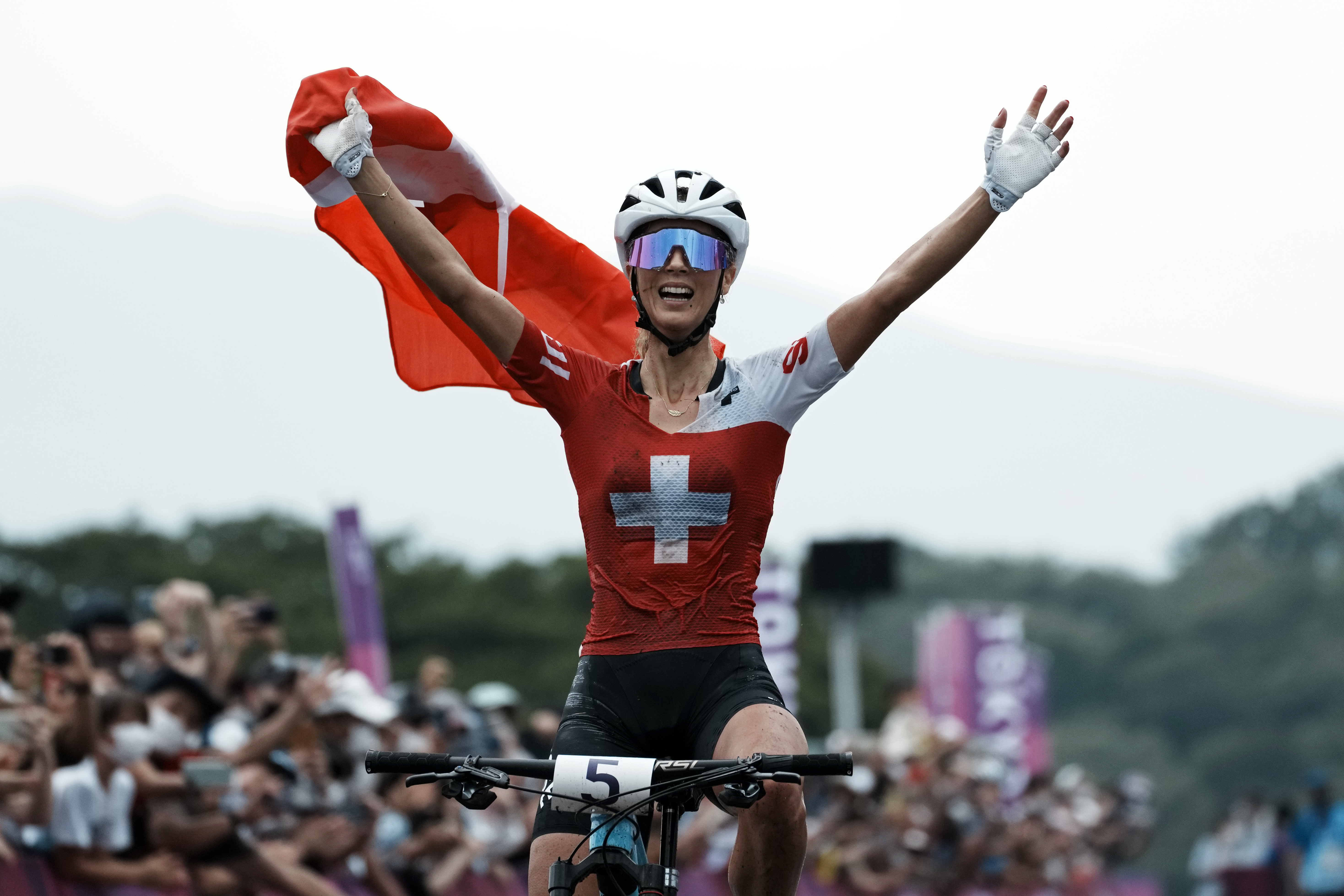 FILE - Jolanda Neff, of Switzerland, celebrates as she crosses the finish line for the gold medal during the women's cross-country mountain bike competition at the 2020 Summer Olympics, Tuesday, July 27, 2021, in Izu, Japan. Olympic mountain bike champion Jolanda Neff and Marlen Reusser withdrew from the Paris Games in a double blow to the hopes of the Swiss cycling team. The Swiss Cycling Federation announced Monday, July 15, 2024, the two riders would not compete at the Summer Games, which begin in just over a week.