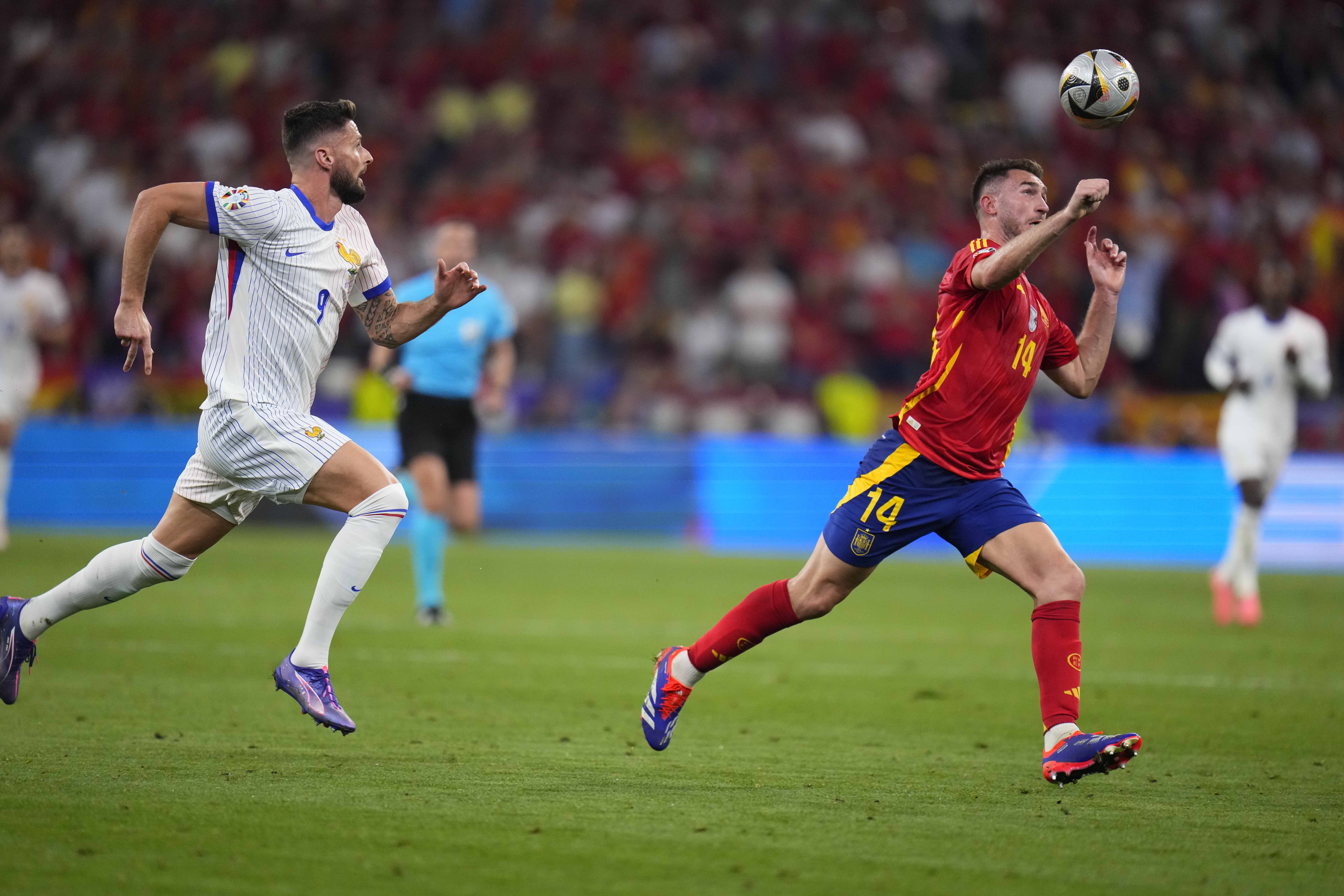 Spain's Aymeric Laporte challenges for the ball with Olivier Giroud of France during a semifinal match between Spain and France at the Euro 2024 soccer tournament in Munich, Germany, Tuesday, July 9, 2024. 