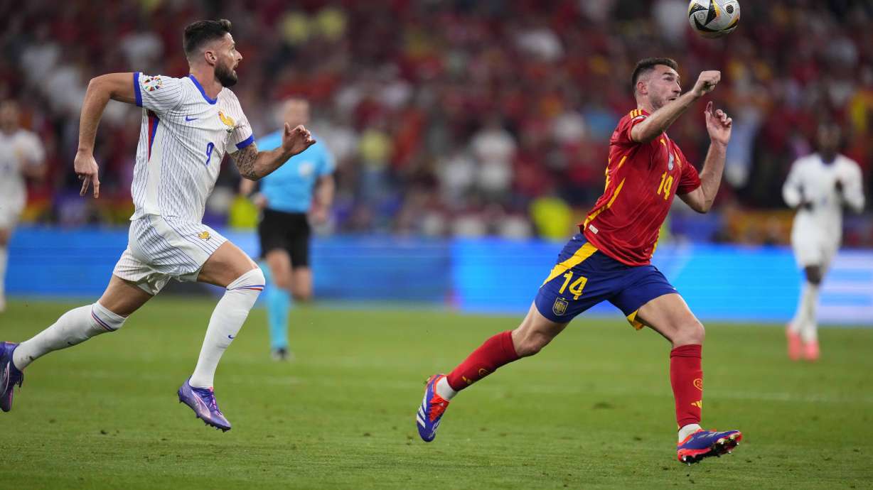 Spain's Aymeric Laporte challenges for the ball with Olivier Giroud of France during a semifinal match between Spain and France at the Euro 2024 soccer tournament in Munich, Germany, Tuesday, July 9, 2024.