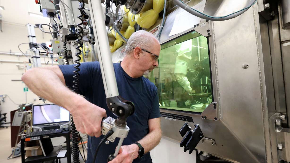 Scott Anderson prepares samples in a hot cell at the Idaho National Laboratory in a remote area west of Idaho Falls, Idaho, on April 5, 2023. The controls he is using maneuver tools like grips, saws and polishers inside the hot cell.
