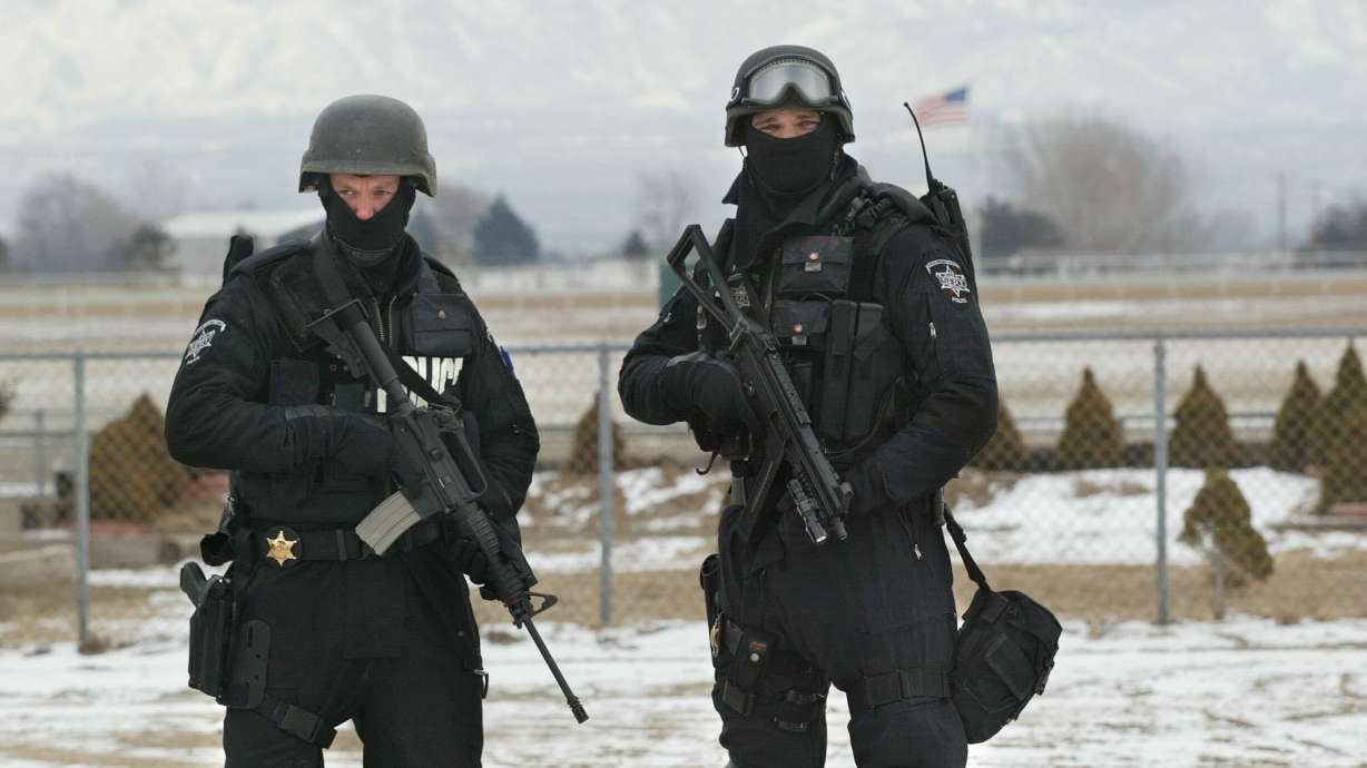 Lt. Todd Peterson and Trooper Brad Marshall pose for a photo as police, fire and EMS agencies display and demonstrate the tools they would use for Olympic security during the Games in Salt Lake City on Jan. 30, 2002.