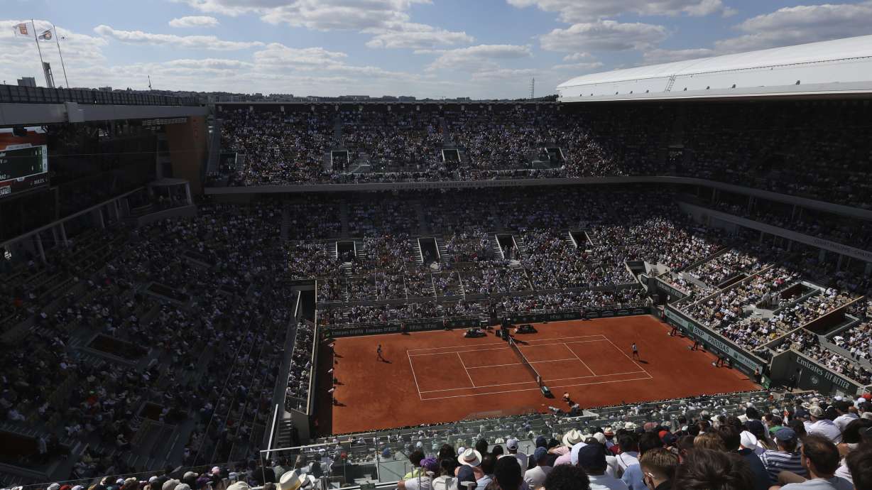FILE - Germany's Alexander Zverev, right, serves against Spain's Carlos Alcaraz during the men's final match of the French Open tennis tournament at the Roland Garros stadium in Paris, June 9, 2024. For the first time in more than 30 years, the tennis competition at an Olympics will be held on red clay, which means players who just made the adjustment from that surface at the French Open in early June to grass at Wimbledon in early July now will need to reverse course again in short order.