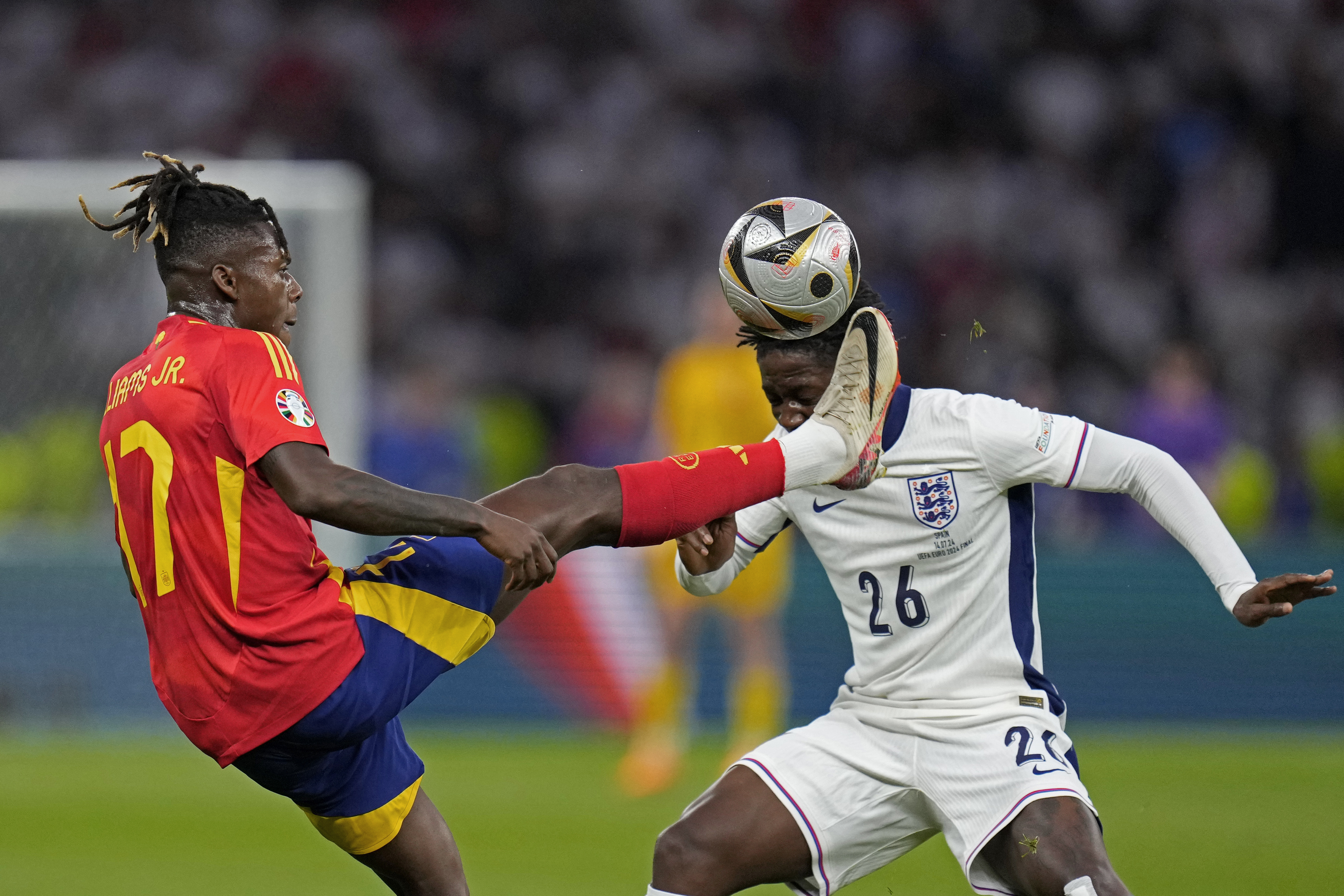 Spain's Nico Williams reaches for the ball in front of England's Kobbie Mainoo during the final match between Spain and England at the Euro 2024 soccer tournament in Berlin, Germany, Sunday, July 14, 2024.