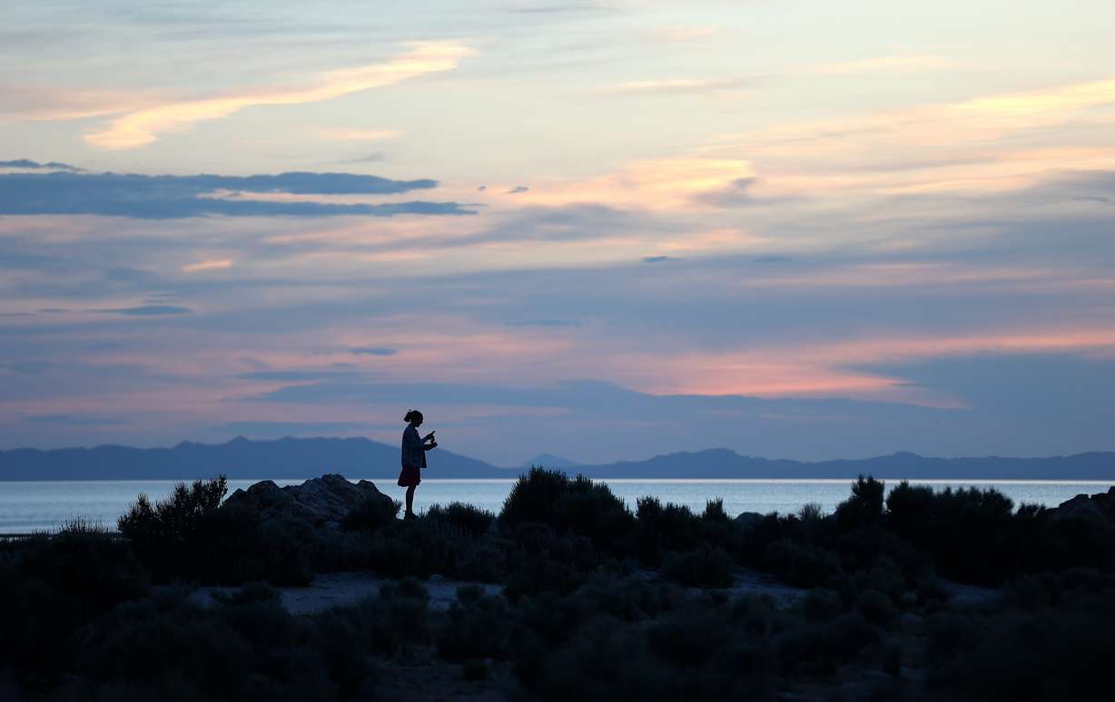 A woman hikes during a sunset at Ladyfinger Point on Antelope Island on June 5, 2023.