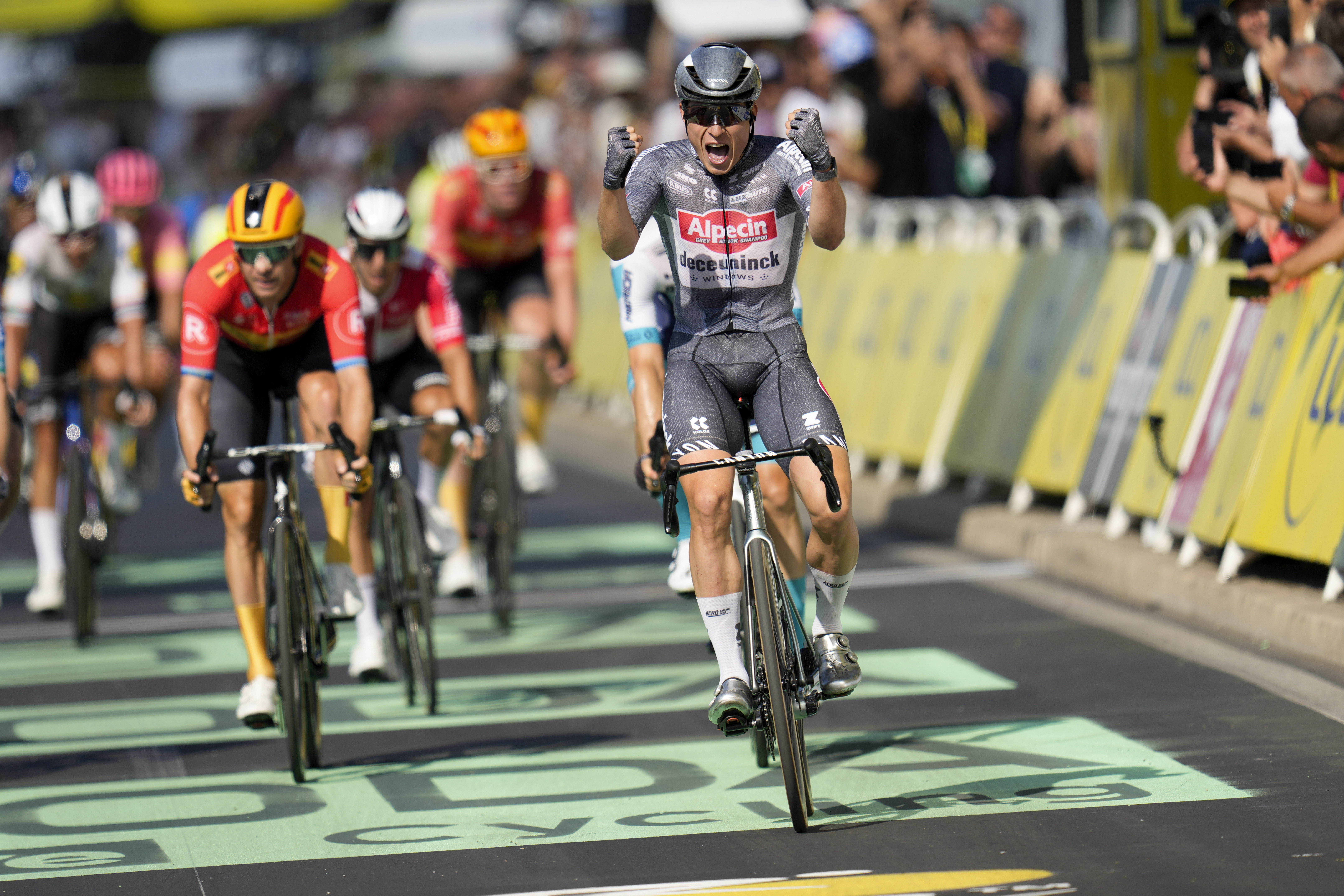 Belgium's Jasper Philipsen celebrates as he crosses the finish line ahead of Norway's Alexander Kristoff, in red, left, to win the sixteenth stage of the Tour de France cycling race over 188.6 kilometers (117.2 miles) with start in Gruissan and finish in Nimes, France, Tuesday, July 16, 2024. 