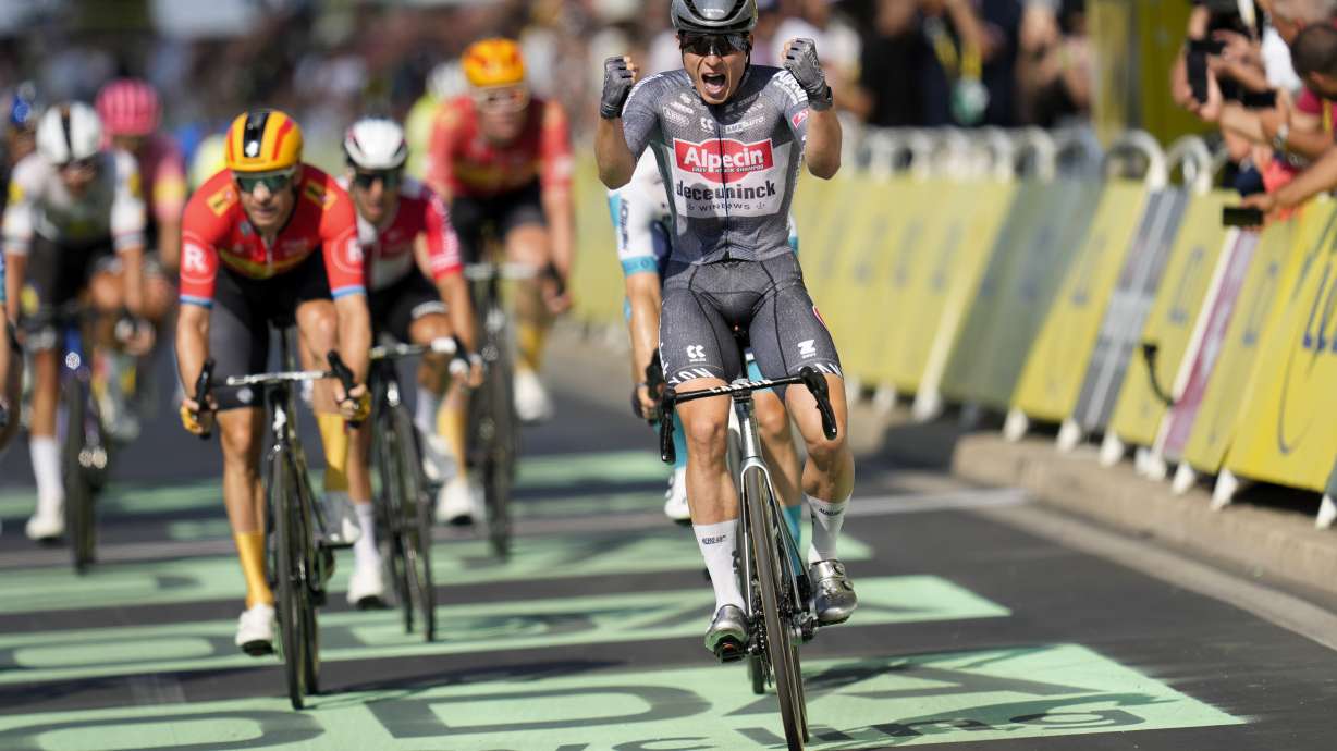 Belgium's Jasper Philipsen celebrates as he crosses the finish line ahead of Norway's Alexander Kristoff, in red, left, to win the sixteenth stage of the Tour de France cycling race over 188.6 kilometers (117.2 miles) with start in Gruissan and finish in Nimes, France, Tuesday, July 16, 2024.