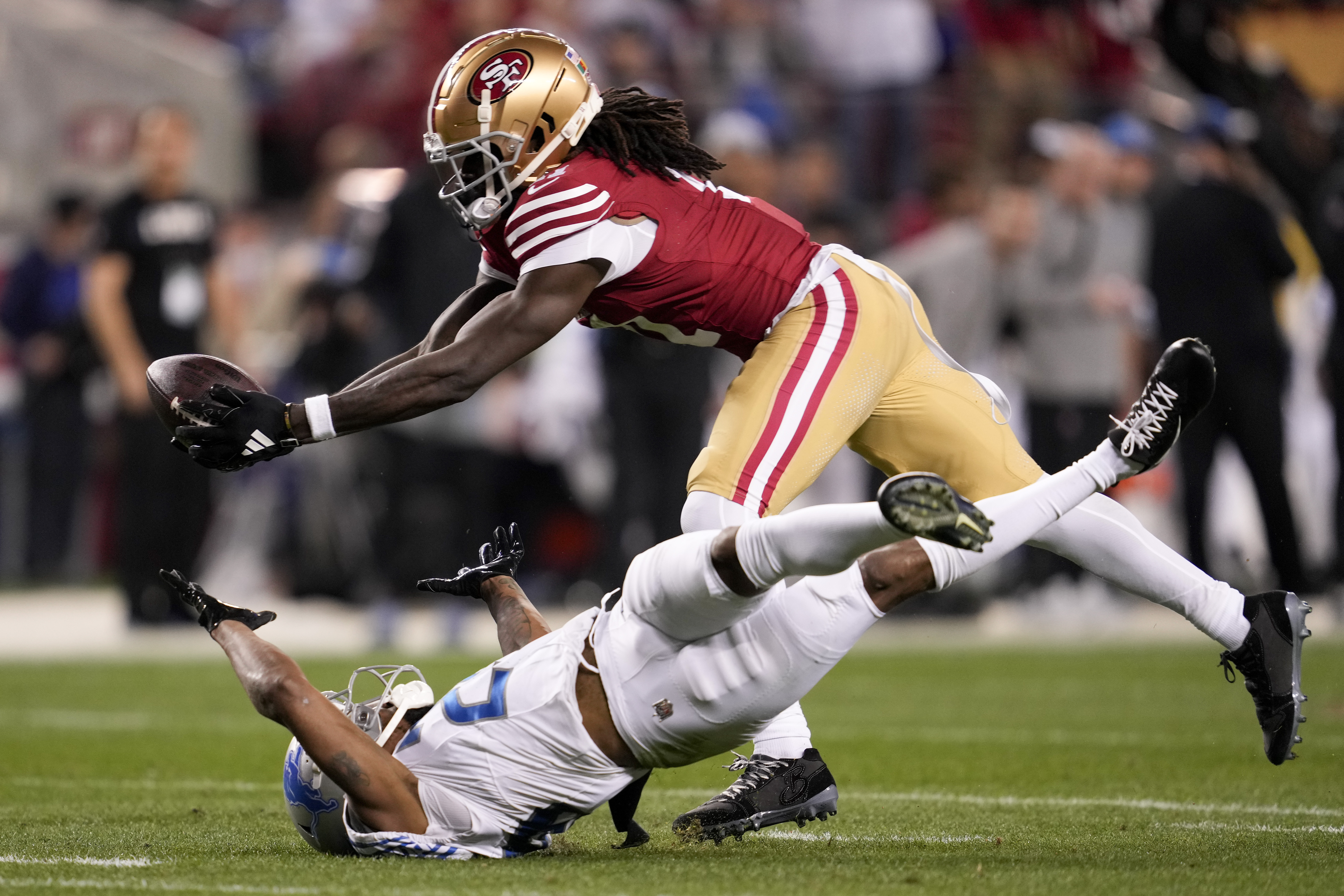 FILE - San Francisco 49ers wide receiver Brandon Aiyuk, top, catches a pass against Detroit Lions cornerback Kindle Vildor (29) during the second half of the NFC Championship NFL football game in Santa Clara, Calif., Sunday, Jan. 28, 2024. Brandon Aiyuk has requested a trade from the San Francisco 49ers because the two sides haven’t made progress on a new contract, a person familiar with the star wide receiver’s decision told The Associated Press on Tuesday, July 16.