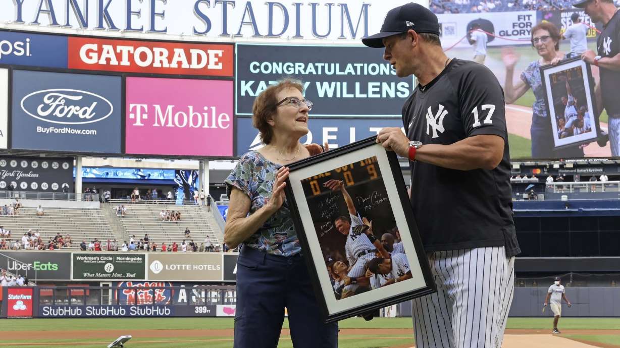 Yankees' Aaron Boone presents an autographed picture to Kathy Willens on June 28, 2021, in New York, of her picture of New York Yankees pitcher David Cone after Cone threw a perfect game.