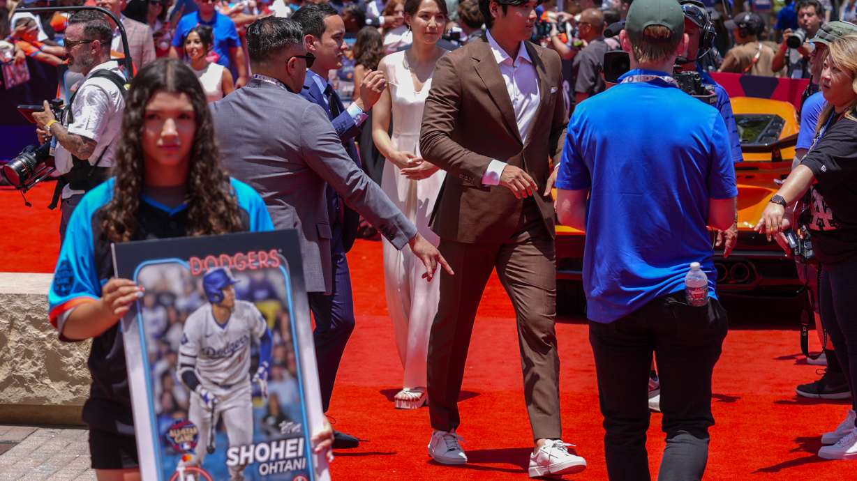 Los Angeles Dodgers' Shohei Ohtani, center, walks with his wife Mamiko Tanaka during the baseball All-Star Game red carpet show, Tuesday, July 16, 2024, in Arlington, Texas.