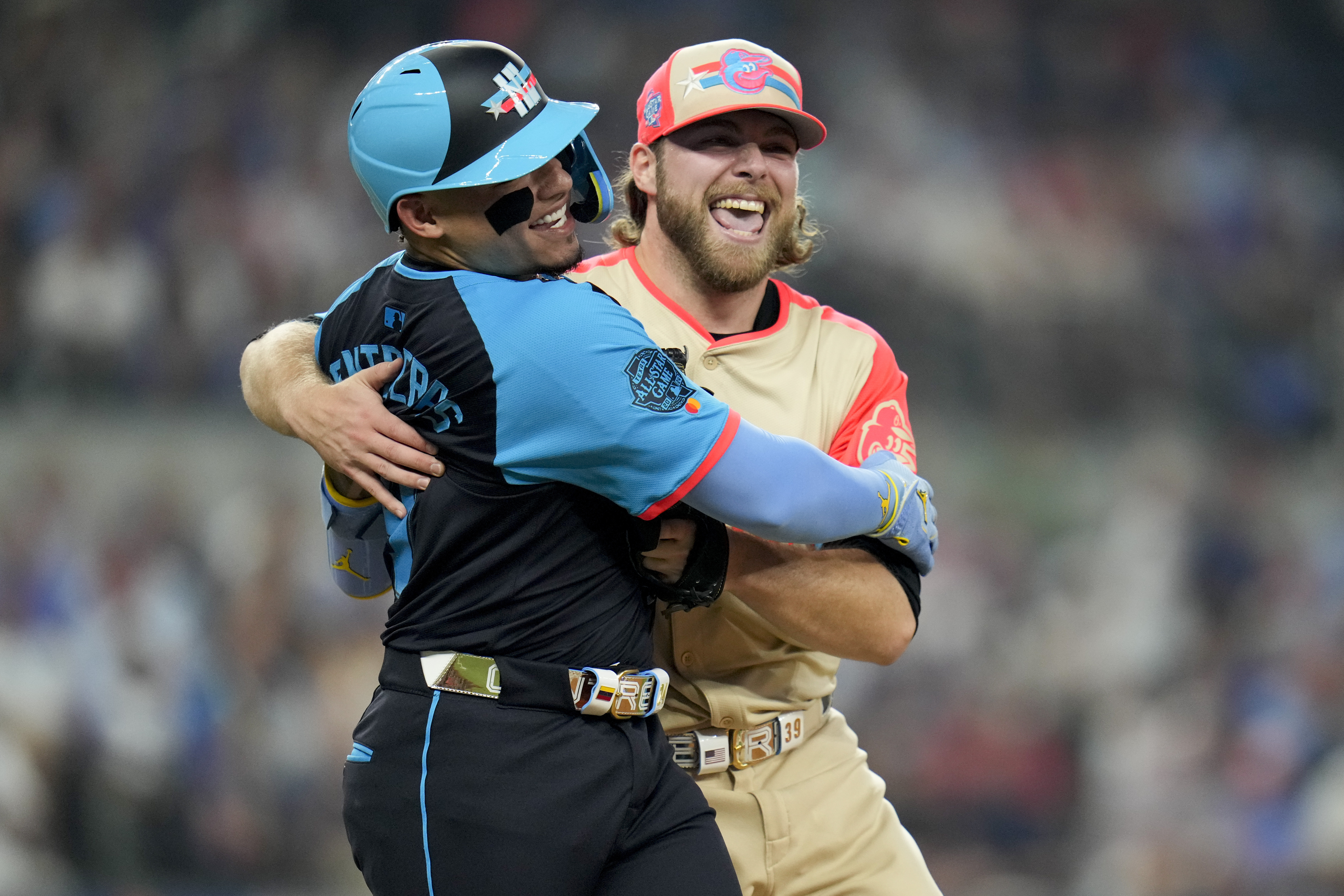 American League starting pitcher Corbin Burnes, of the Baltimore Orioles, right, hugs National League's William Contreras, of the Milwaukee Brewers, after an out on a ground ball by Contreras in the first inning during the MLB All-Star baseball game, Tuesday, July 16, 2024, in Arlington, Texas. 