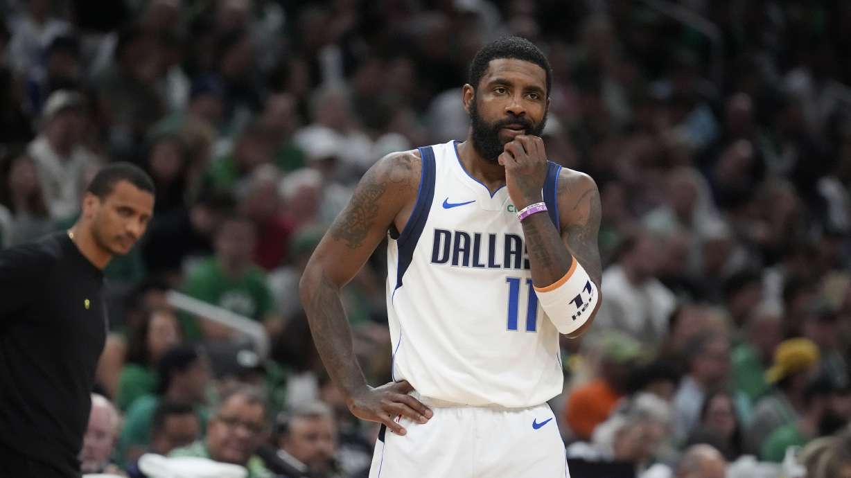 FILE - Dallas Mavericks guard Kyrie Irving pauses on the court in front of Boston Celtics head coach Joe Mazzulla, left, during the first half of Game 5 of the NBA basketball finals, June 17, 2024, in Boston. Irving has a broken left hand that required surgery after getting injured in an offseason workout. The Dallas Mavericks aren't providing a timeline for Irving's recovery.