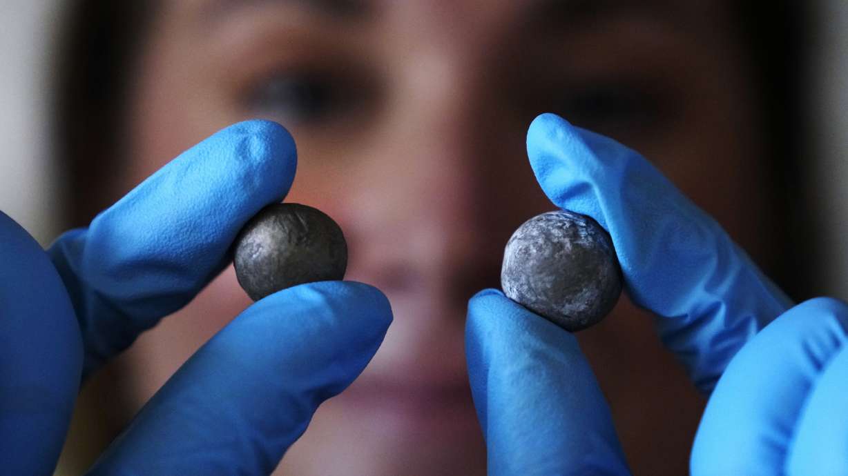 Museum curator Nikki Walsh holds up two Revolutionary War musket balls, which are believed to be fired at the British by colonial militia men, at Minute Man National Historical Park, Monday in Concord, Mass.