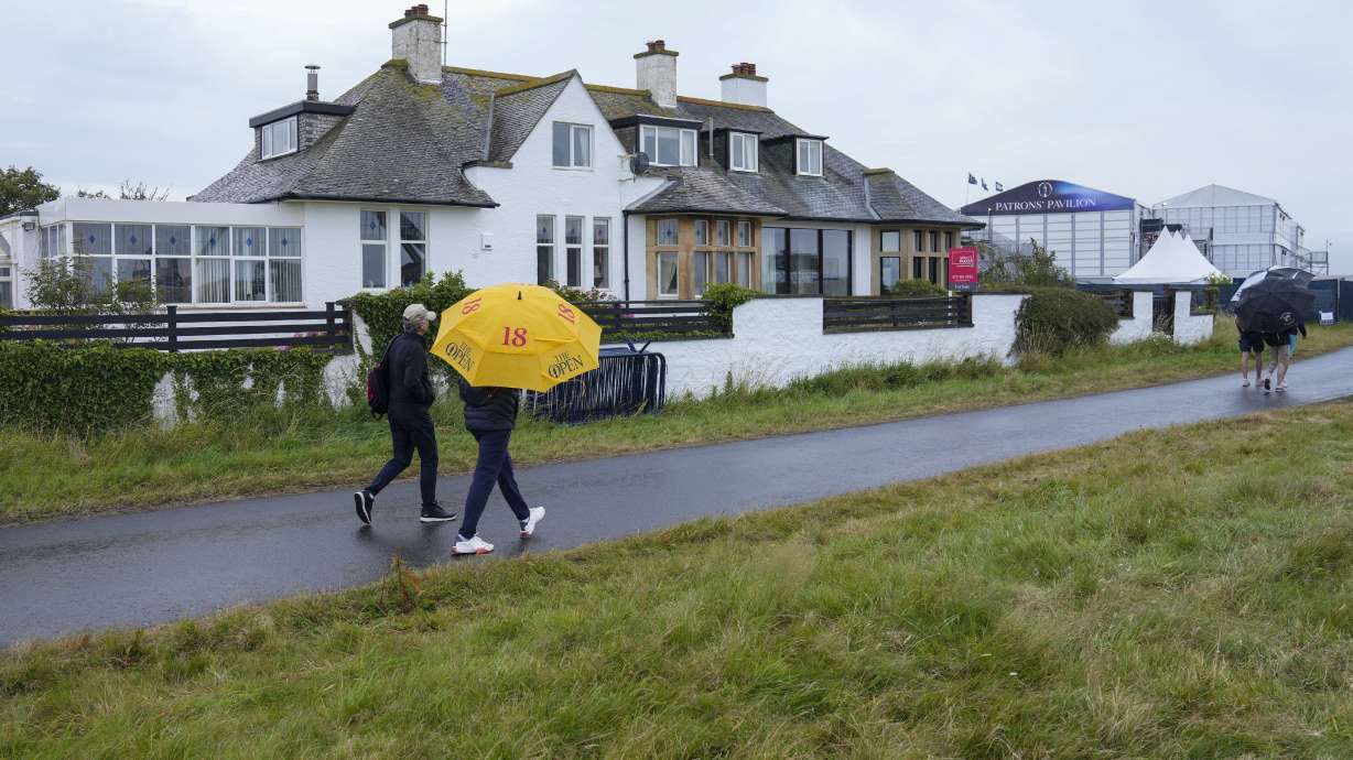 Spectators walk past "Blackrock house" that is listed for sale near the second and 16th holes at Royal Troon golf club, venue for the British Open Golf Championships, in Troon, Scotland, Tuesday, July 16, 2024. Royal Troon has some unique aspects but maybe most curious is the private house that sits in the middle of the championship course and has views of five holes.
