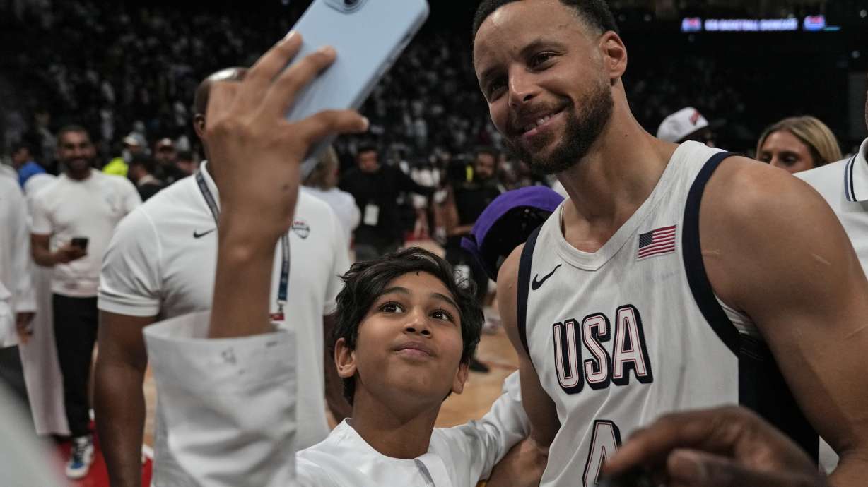United States' Stephen Curry takes a selfie with a fan after an exhibition basketball match between Serbia and the United States at the USA Basketball Showcase, ahead of the 2024 Paris Olympic basketball tournament, in Abu Dhabi, United Arab Emirates, Wednesday, July 17, 2024.