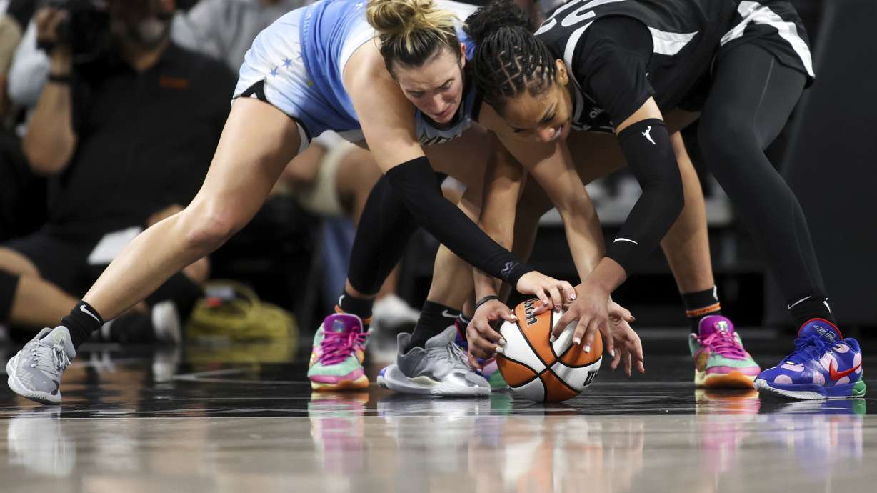 Chicago Sky guard Marina Mabrey, left, and Las Vegas Aces center A'ja Wilson struggle for a loose ball during the second half of a WNBA basketball game, Tuesday, July 16, 2024, in Las Vegas.