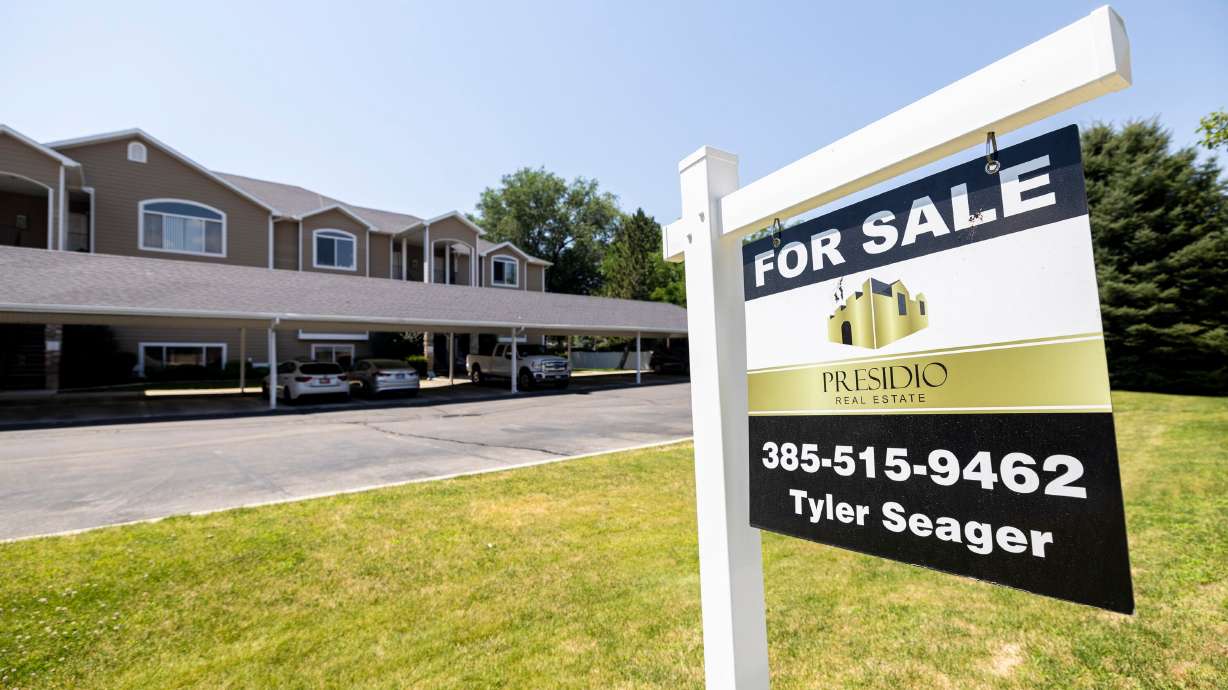 A “For Sale” sign is displayed outside apartments in Orem on Wednesday. Choosing to rent or buy seems more like choosing the lesser of two evils in 2024, say experts.