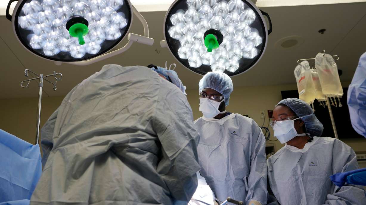 Meharry Medical College students Emmanuel Kotey, center, and Teresa Belledent, right, watch as the liver and kidneys are removed from an organ donor, June 15, in Jackson, Tenn.