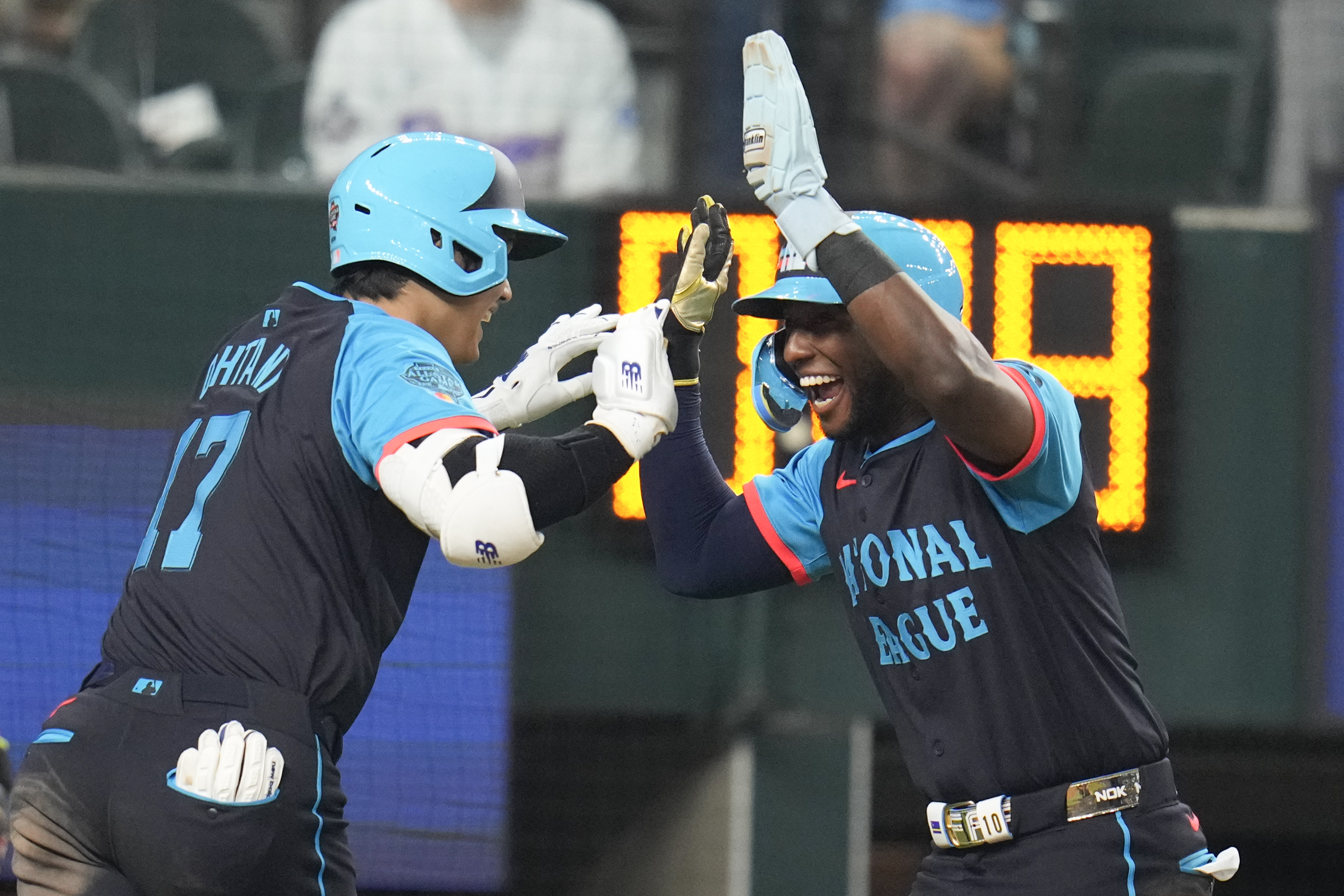 National League's Shohei Ohtani, of the Los Angeles Dodgers, left, celebrates his three-run home with Jurickson Profar, of the San Diego Padres, in the third inning during the MLB All-Star baseball game, Tuesday, July 16, 2024, in Arlington, Texas. 