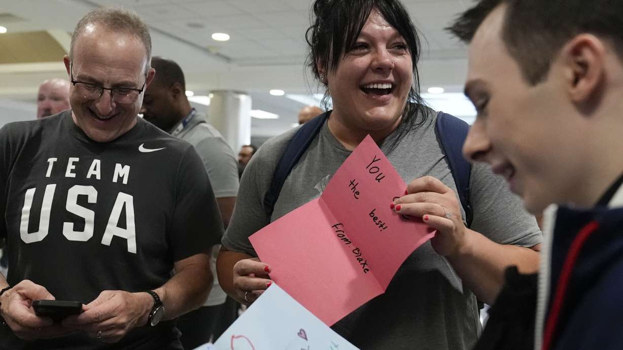 Team USA weightlifting athlete, Mary Theisen smiles as they read an encouraging note from a local high schooler as they depart from the airport for the Summer Olympic Games, on Wednesday, July 17, 2024, in Atlanta.