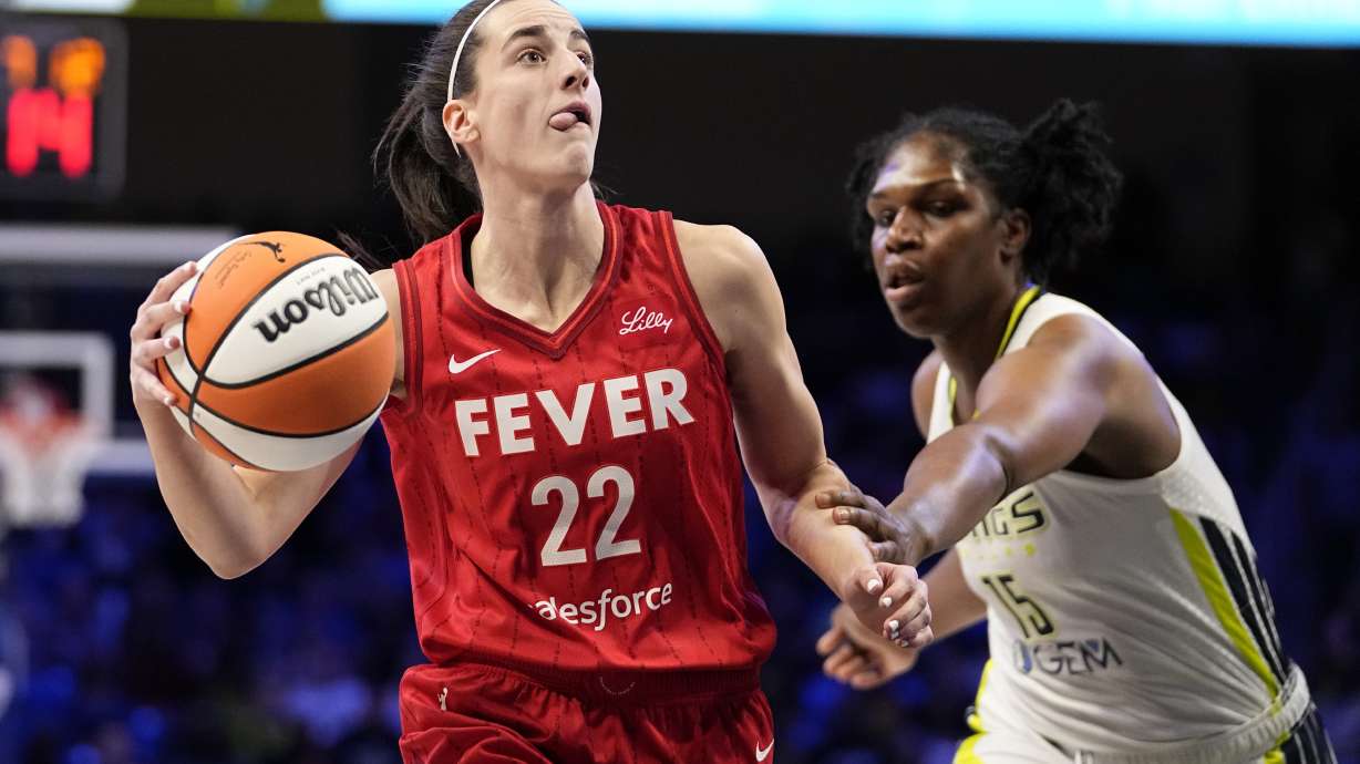 Indiana Fever's Caitlin Clark (22) drives to the basket past Dallas Wings' Teaira McCowan in the first half of a WNBA basketball game Wednesday, July 17, 2024, in Arlington, Texas.