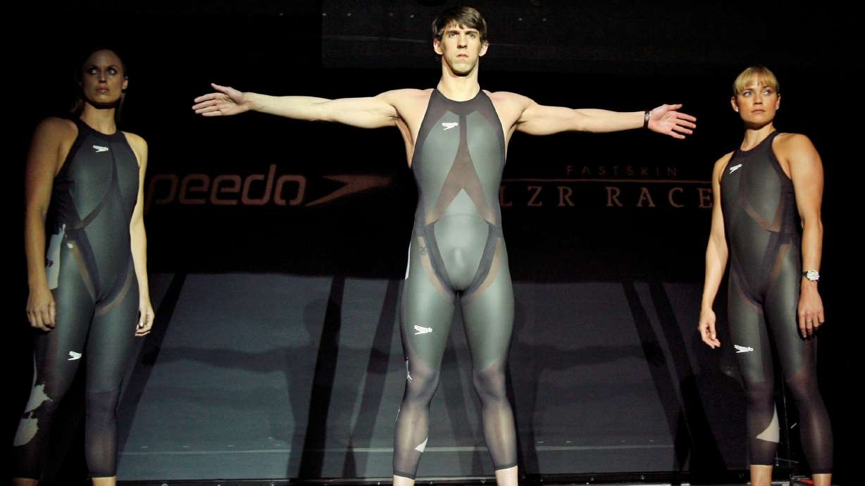 FILE - American Olympic medalists Amanda Beard, left, Natalie Coughlin, right, and Michael Phelps pose in Speedo "LZR Racer" swimsuits during a news conference introducing the suits in New York, Feb. 12, 2008. The iconic LZR Racer, the swimsuit that Michael Phelps wore while winning eight golds medals at the Beijing Olympics, is still revered around Speedo's design center.