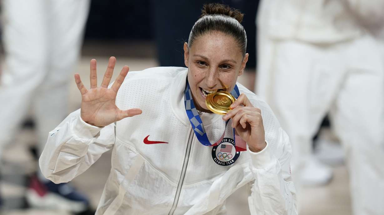 FILE - United States's Diana Taurasi bites her gold medal during the medal ceremony for women's basketball at the 2020 Summer Olympics, Sunday, Aug. 8, 2021, in Saitama, Japan. The 42-year-old guard will be playing in a record sixth Olympics when the U.S. goes for its eighth consecutive gold medal.