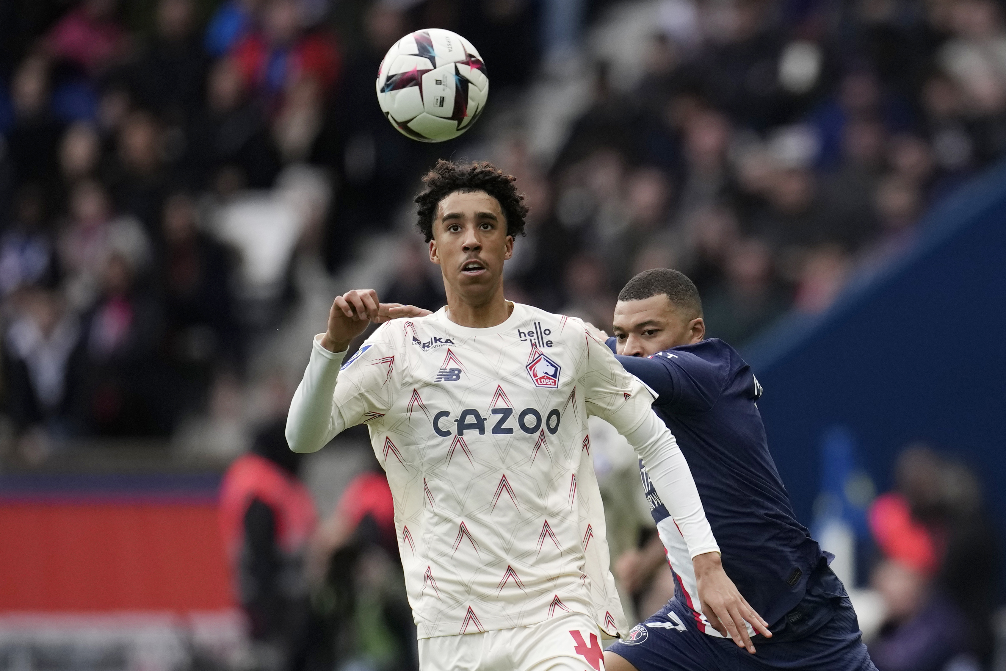FILE - Lille's Leny Yoro controls the ball next to PSG's Kylian Mbappe, right, during the French League One soccer match between Paris Saint-Germain and Lille at the Parc des Princes stadium, in Paris, France, Sunday, Feb. 19, 2023. Manchester United completed the signing of 18-year-old defender Leny Yoro from Lille on Thursday, July 18, 2024.