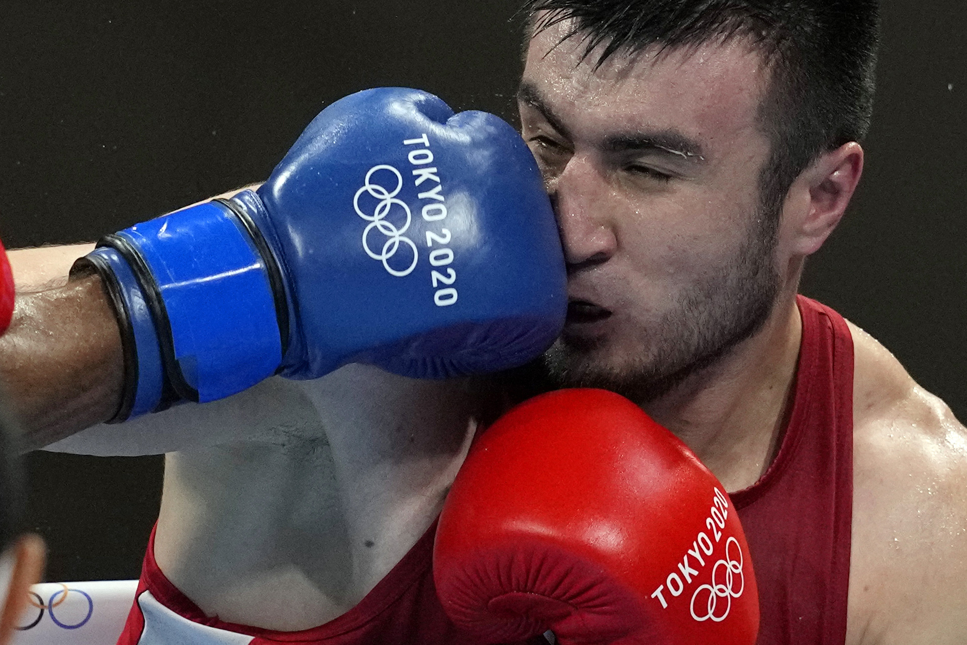 FILE - Bakhodir Jalolov, of Uzbekistan, takes a shot in the nose from Great Britains' Frazer Clarke during their super heavy weight +91kg semifinal boxing match at the 2020 Summer Olympics, Wednesday, Aug. 4, 2021, in Tokyo, Japan. A sport that has been a staple of Olympic programs for over a century, boxing could be dropped before the Los Angeles Games if big changes in governance don't happen in the next year or two. (AP Photo/Themba Hadebe, FIle(