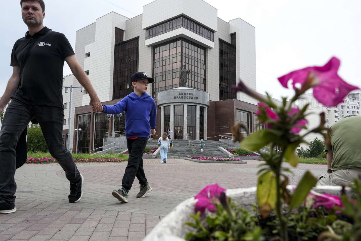 People walk past the court building with the words reading, "Palace of justice," on the front in Yekaterinburg, Russia, Friday, prior to the trial of Wall Street Journal reporter Evan Gershkovich's suspected spying activities. He was convicted Friday and sentenced to 16 years in a maximum-security prison.