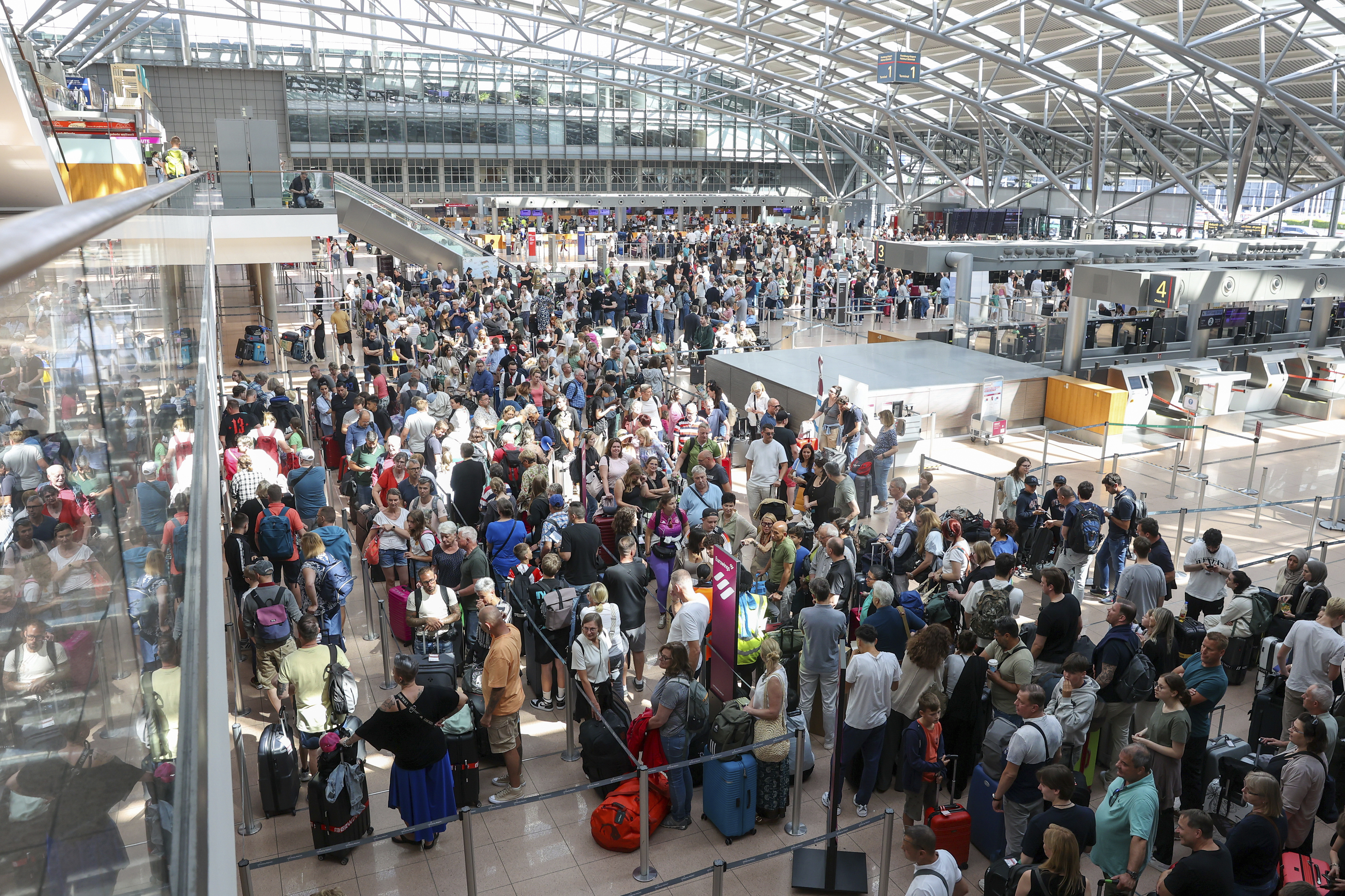 Travelers wait in Terminal 1 for check-in at Hamburg Airport, in Hamburg, Germany, Friday as a widespread Microsoft outage disrupted flights, banks, media outlets and companies around the world.