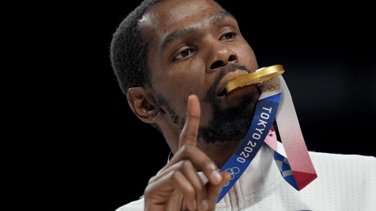FILE - Kevin Durant poses for a photo with his gold medal during the medal ceremony for basketball game at the 2020 Summer Olympics, Aug. 7, 2021, in Tokyo, Japan.