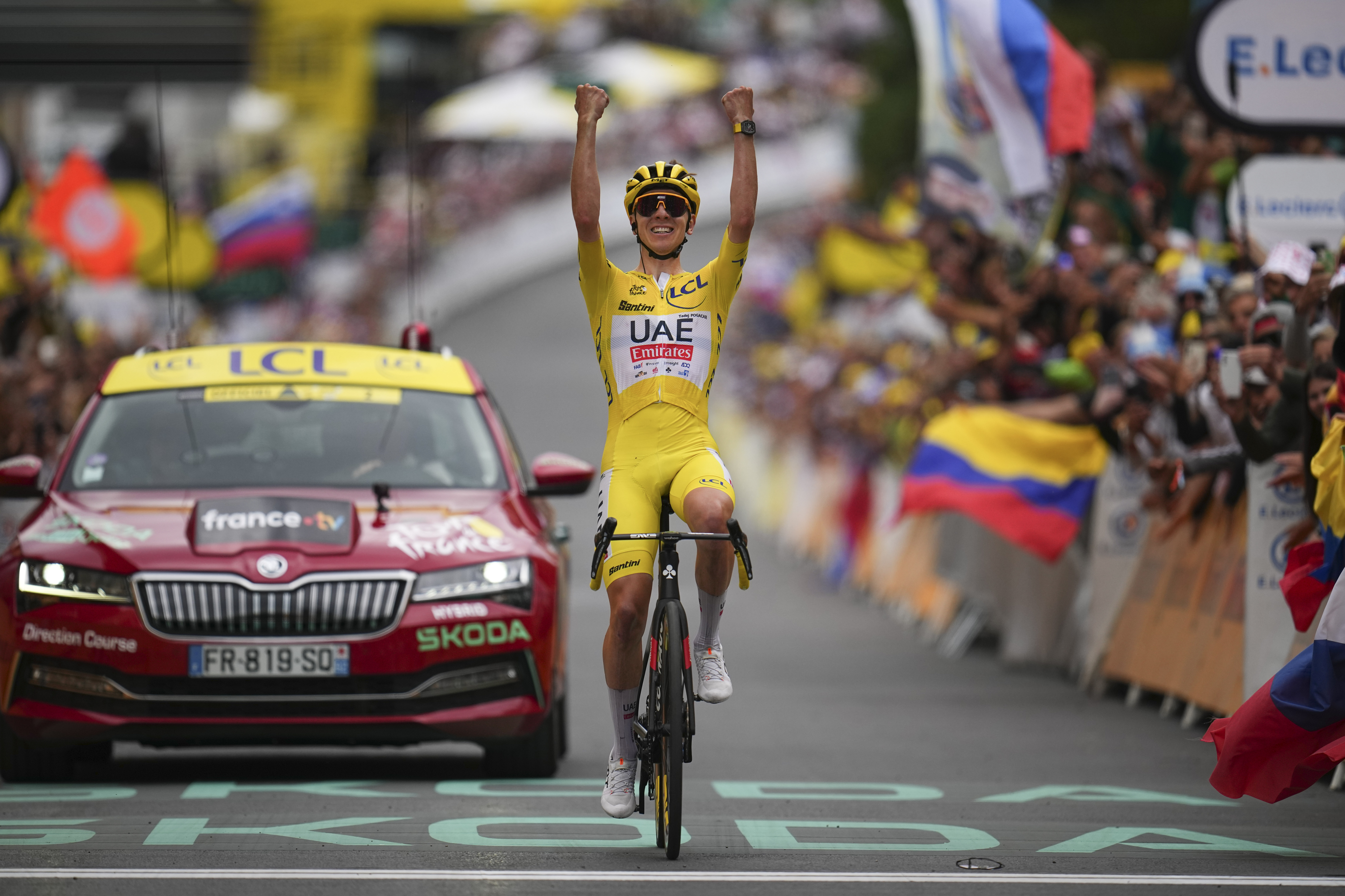 Slovenia's Tadej Pogacar, wearing the overall leader's yellow jersey, celebrates as he crosses the finish line to win the nineteenth stage of the Tour de France cycling race over 144.6 kilometers (89.9 miles) with start in Embrun and finish in Isola 2000, France, Friday, July 19, 2024. 