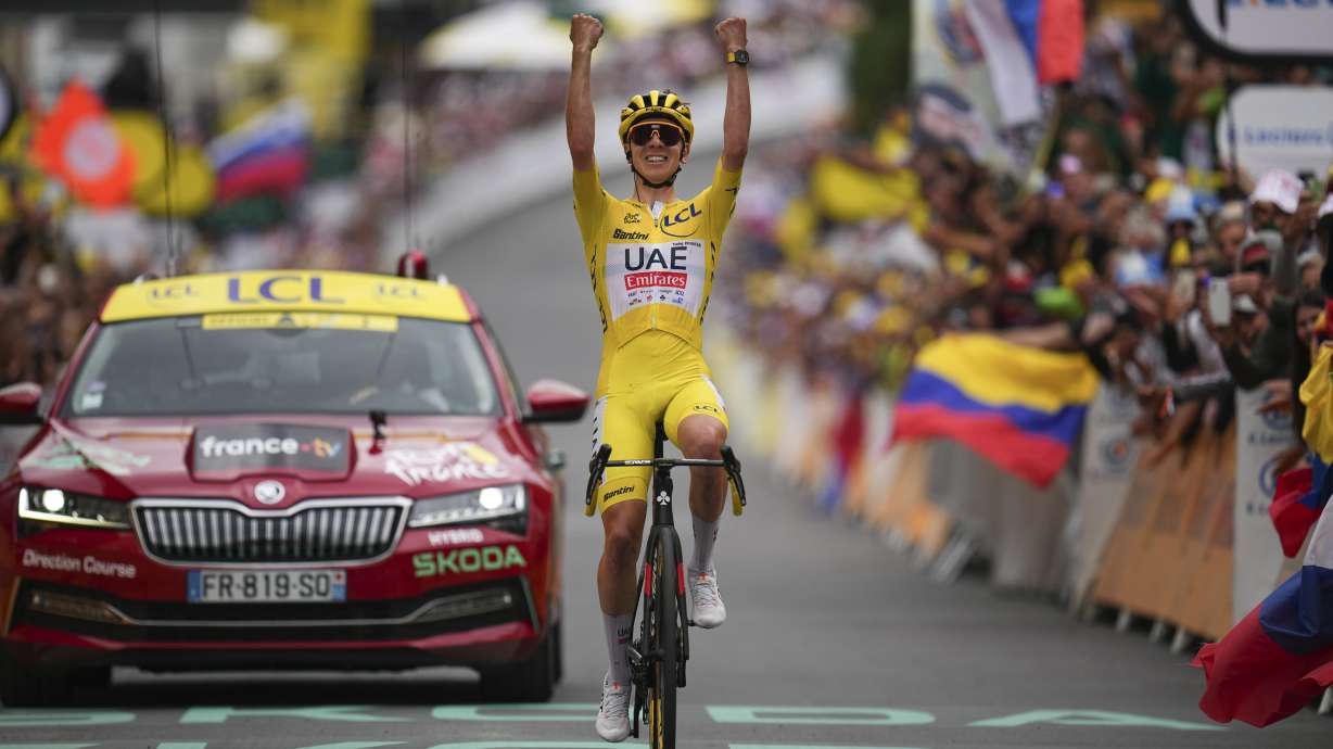 Slovenia's Tadej Pogacar, wearing the overall leader's yellow jersey, celebrates as he crosses the finish line to win the nineteenth stage of the Tour de France cycling race over 144.6 kilometers (89.9 miles) with start in Embrun and finish in Isola 2000, France, Friday, July 19, 2024.