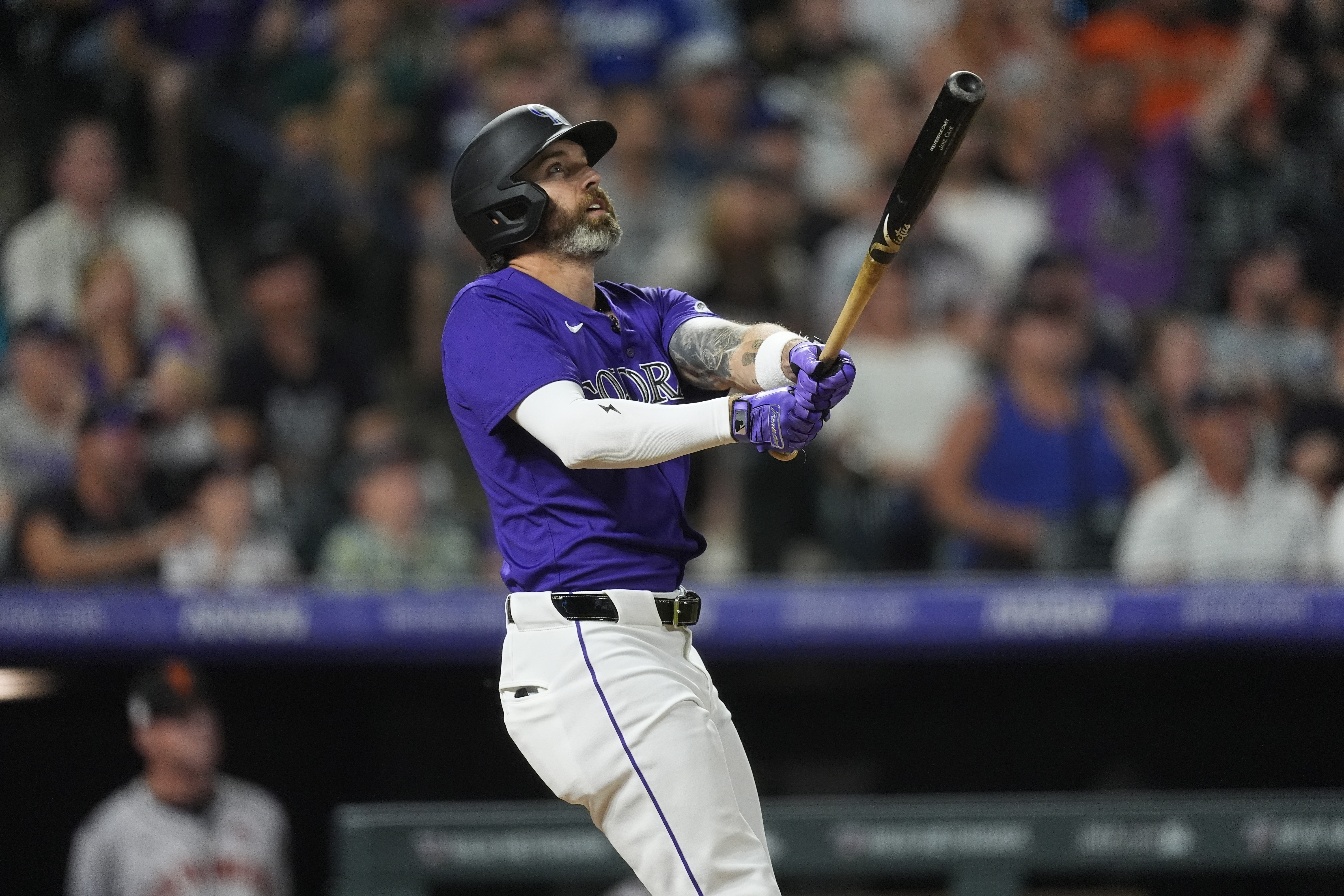Colorado Rockies' Jake Cave follows the flight of his three-run home run off San Francisco Giants relief pitcher Tyler Rogers in the eighth inning of a baseball game Friday, July 19, 2024, in Denver. 