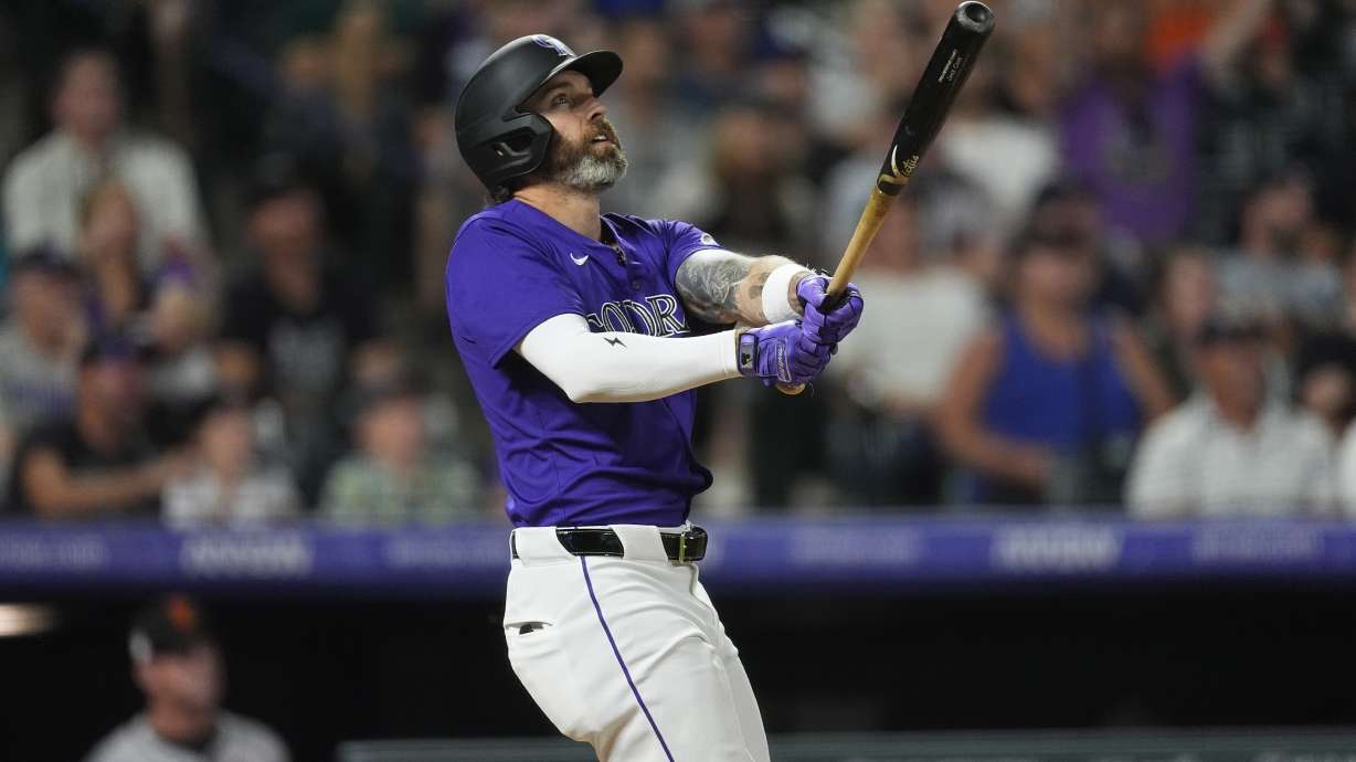 Colorado Rockies' Jake Cave follows the flight of his three-run home run off San Francisco Giants relief pitcher Tyler Rogers in the eighth inning of a baseball game Friday, July 19, 2024, in Denver.
